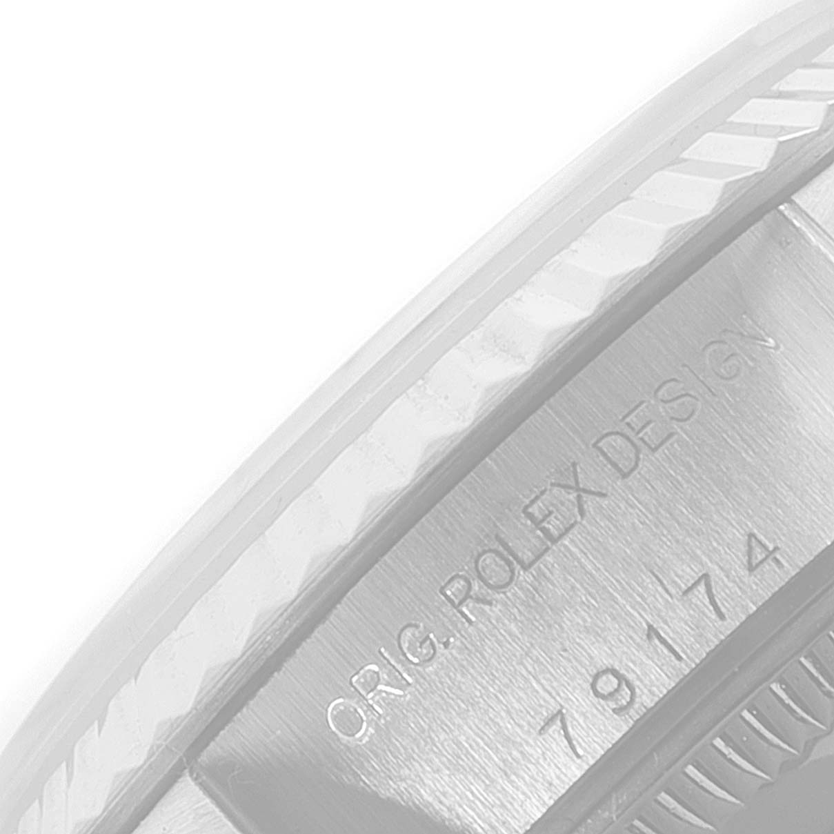 The image shows a close-up of the bezel and case side of a Rolex Datejust 79174 Women's Stainless Steel Pink Dial 79174 Women's Stainless Steel Pink Dial, displaying the model's engraved design and serial number.