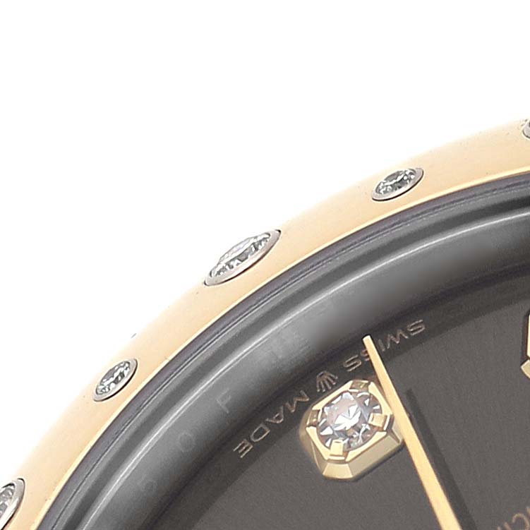 The image shows a close-up of the bezel and part of the dial of a mid-size Rolex watch, highlighting its details.