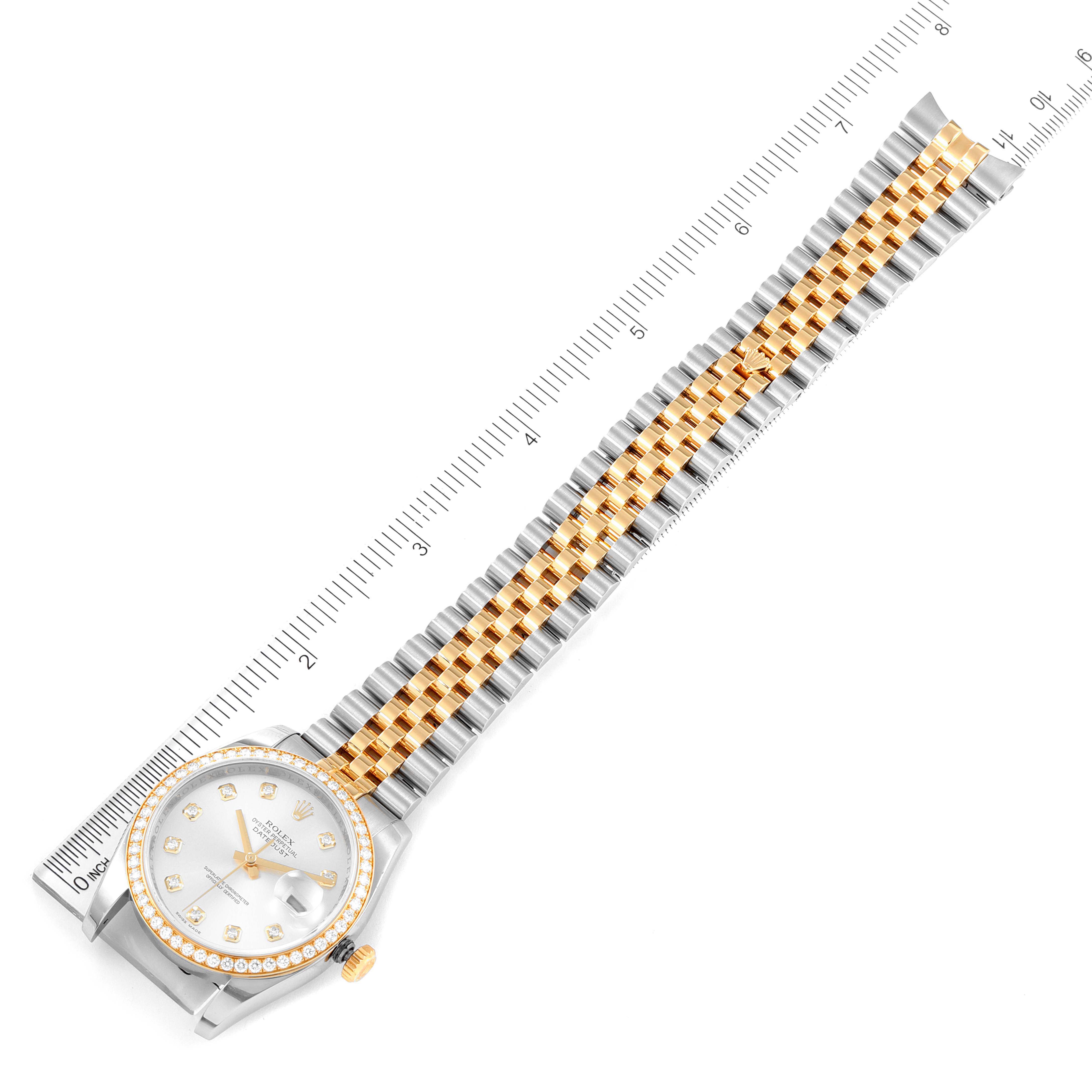 This image shows a Rolex Datejust 116243 Men's Steel and Gold (two tone) Silver Dial 116243 Men's Steel and Gold (two tone) Silver Dial watch with its face and band laid flat, alongside a ruler for scale reference.