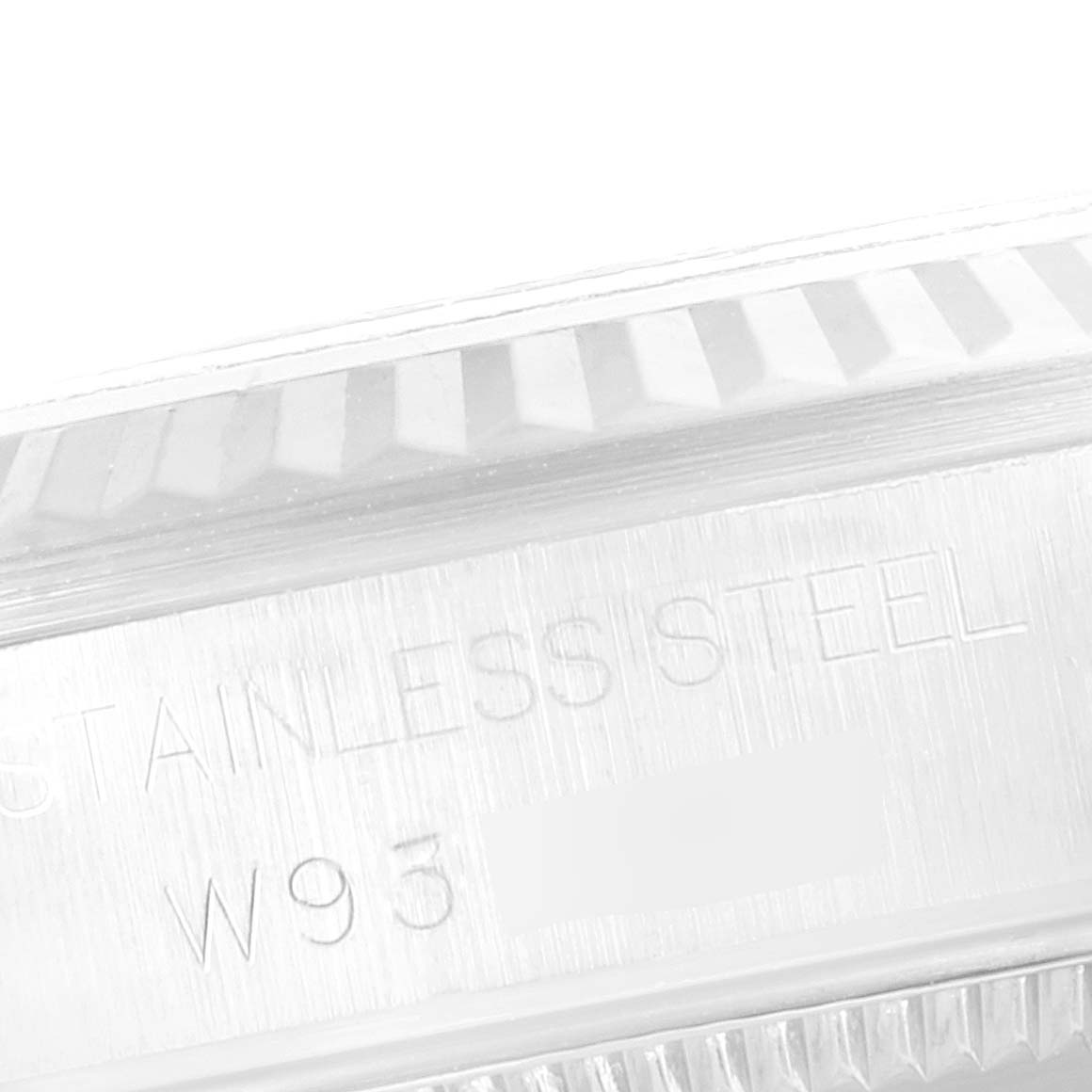 The image shows a close-up angle of the side engraving and fluted bezel of a Mid-Size Rolex watch.