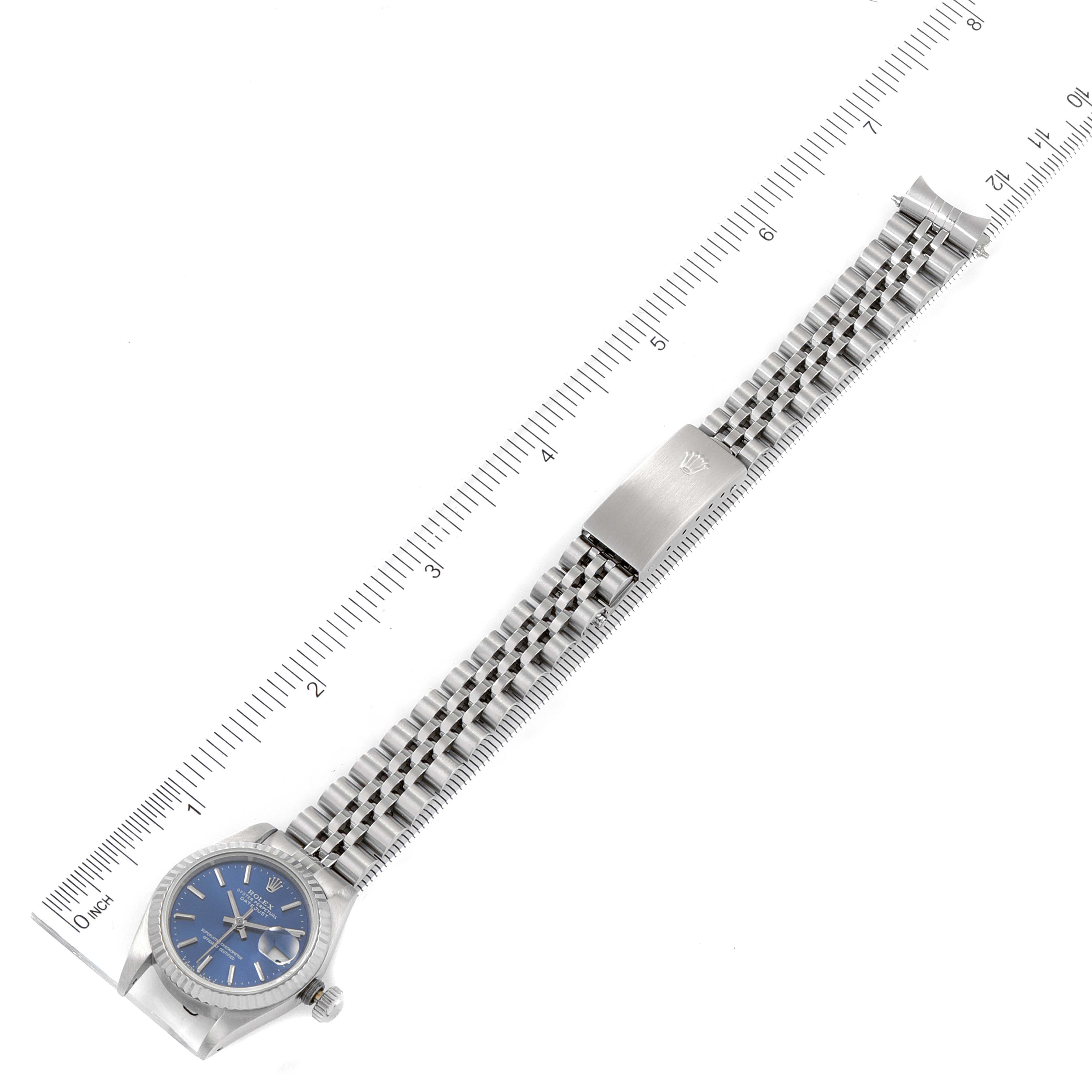 The Rolex Datejust 69174 Women's Stainless Steel Blue Dial 69174 Women's Stainless Steel Blue Dial watch is displayed flat with its face, bracelet, and clasp visible, alongside a measuring ruler.