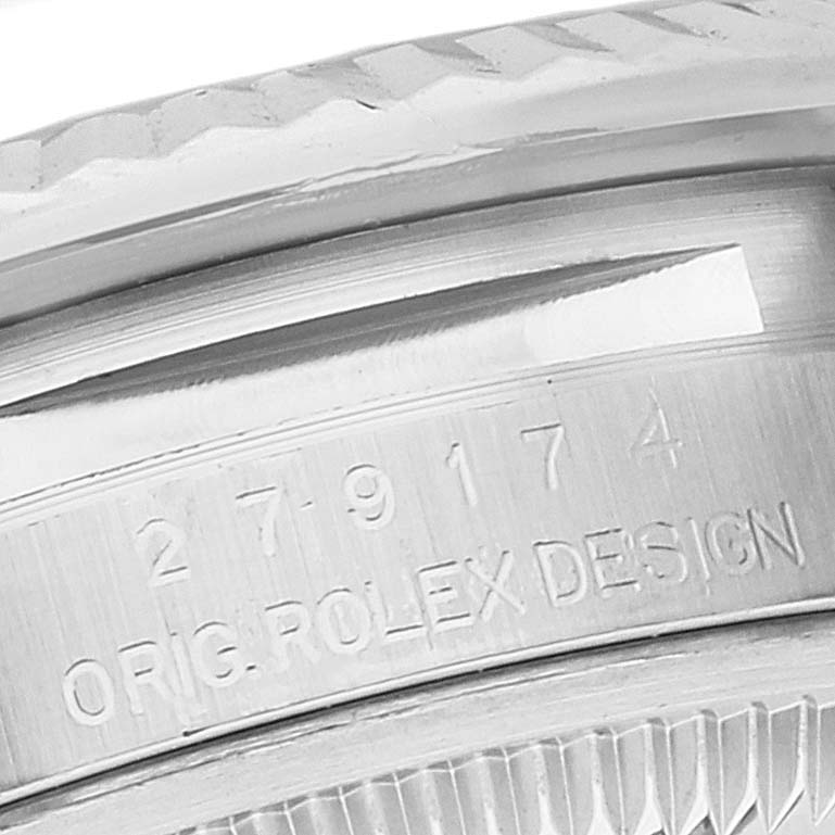The image shows a close-up of a Datejust Rolex watch, focusing on the fluted bezel and part of the case with engraved text.
