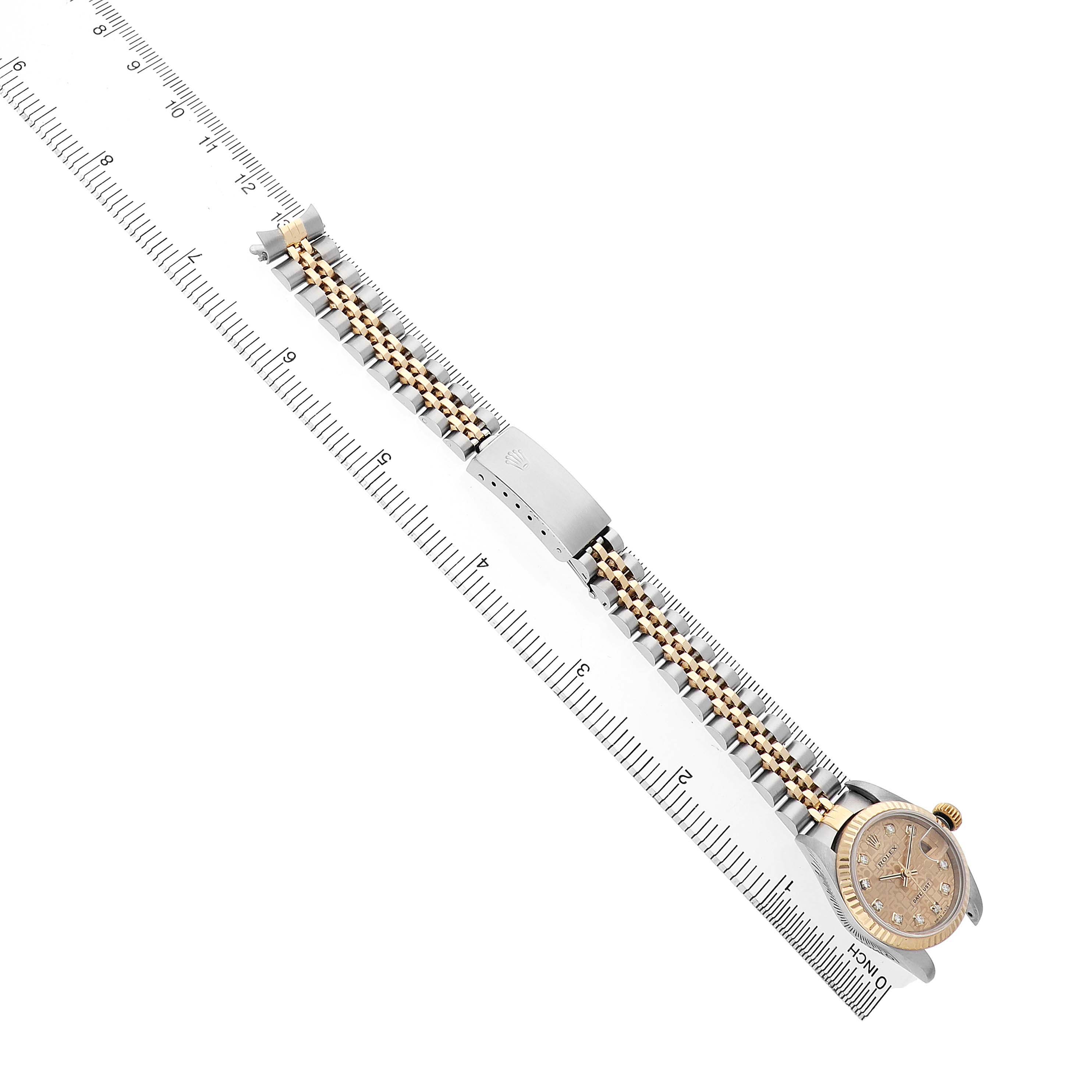 The Rolex Datejust 79173 Women's Steel and Gold (two tone) Champagne Dial watch is shown from a top-down angle, featuring the dial, bezel, and full bracelet laid flat against a ruler.