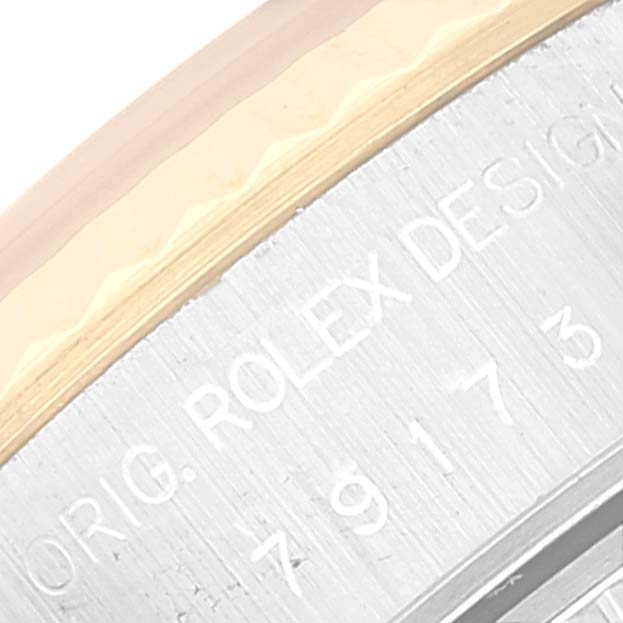 This image shows a close-up of the Rolex Datejust 79173 Women's Steel and Gold (two tone) Champagne Dial 79173 Women's Steel and Gold (two tone) Champagne Dial model's bezel and engraved serial number.