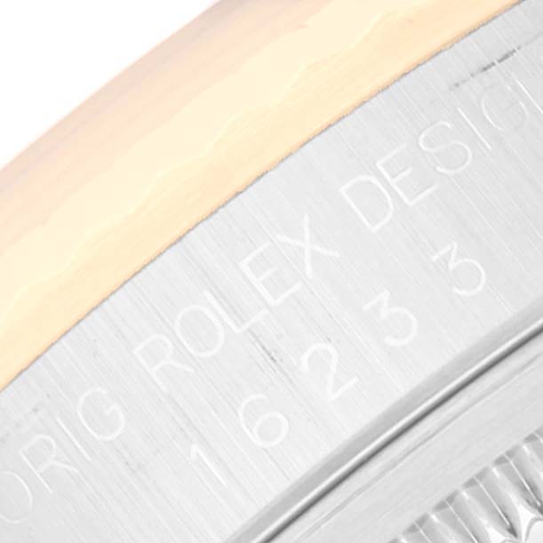 A close-up of the Rolex Datejust 16233 Men's Steel and Gold (two tone) Champagne Dial 16233 Men's Steel and Gold (two tone) Champagne Dial watch showing part of the bezel and case with engraved text.