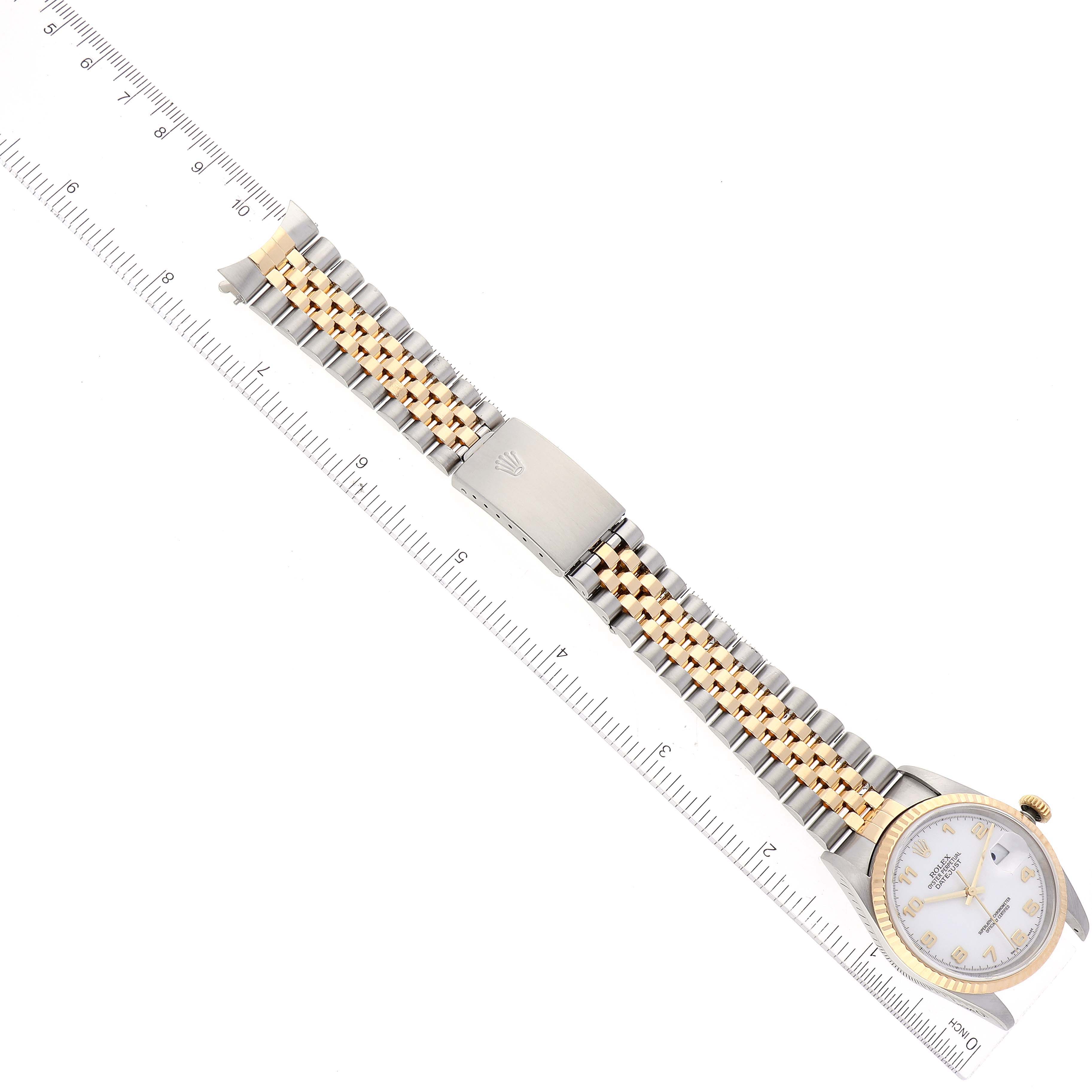 This image shows a Rolex Datejust 16233 Men's Steel and Gold (two tone) White Dial 16233 Men's Steel and Gold (two tone) White Dial watch from a top-down angle, highlighting the bracelet, dial, and an attached ruler for scale.