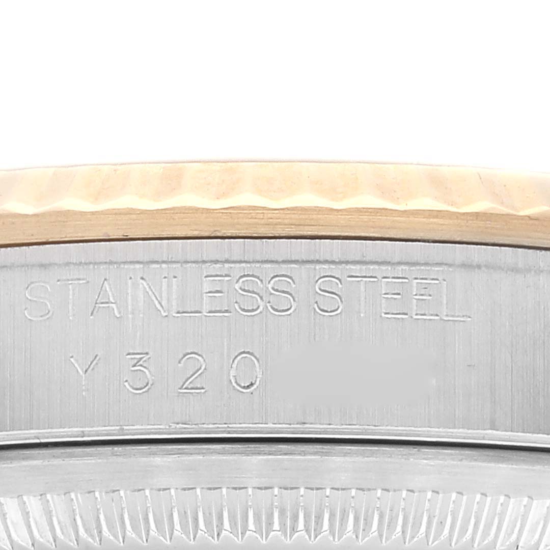 This close-up image of a Rolex Datejust 16233 Men's Steel and Gold (two tone) White Dial 16233 Men's Steel and Gold (two tone) White Dial watch shows the stainless steel case back with engraved text and part of the fluted bezel.