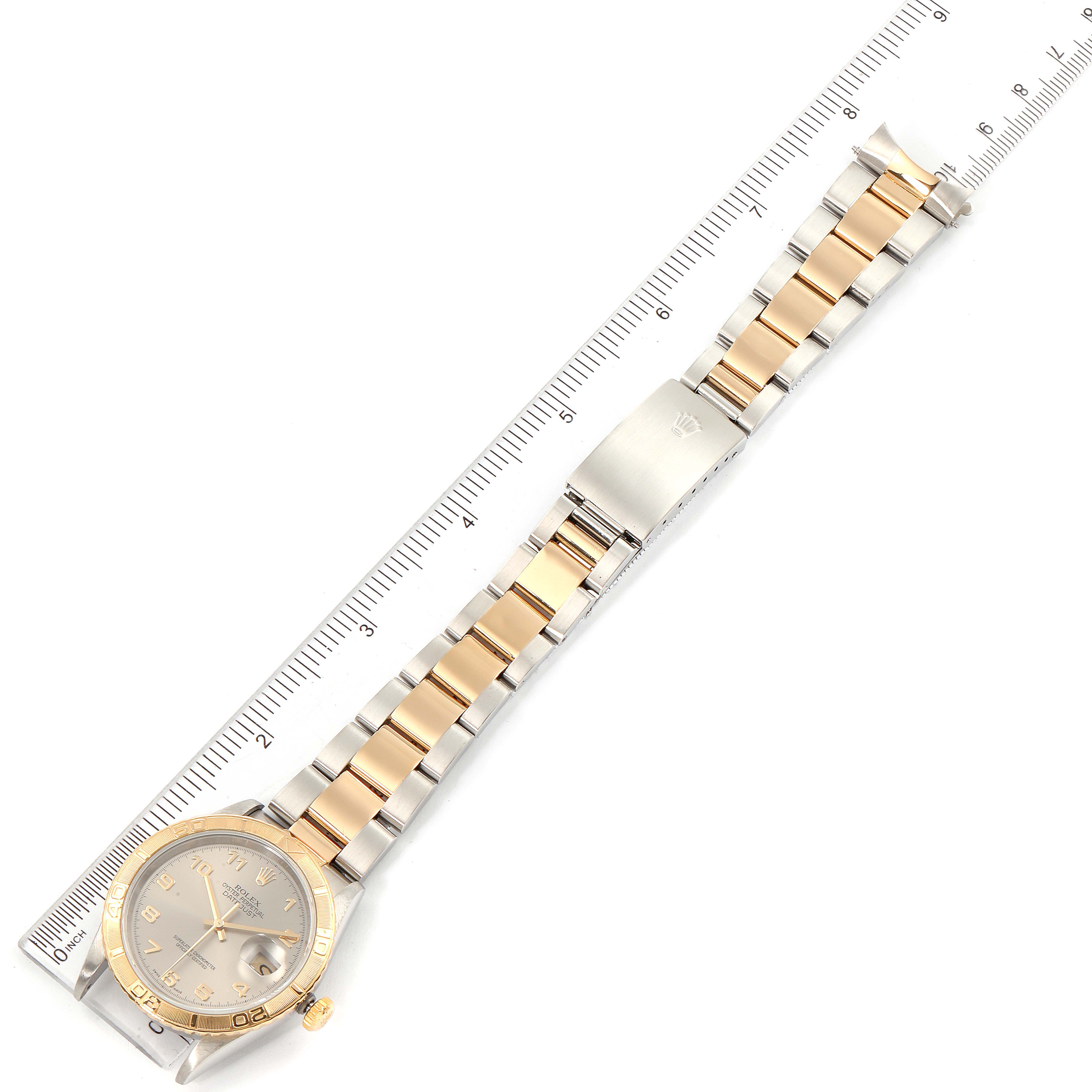 The image shows a gold and steel Rolex Turn-o-Graph 16263 Men's Steel and Gold (two tone) Grey Dial 16263 Men's Steel and Gold (two tone) Grey Dial watch laid flat with the face, bracelet, and clasp visible, next to a ruler.
