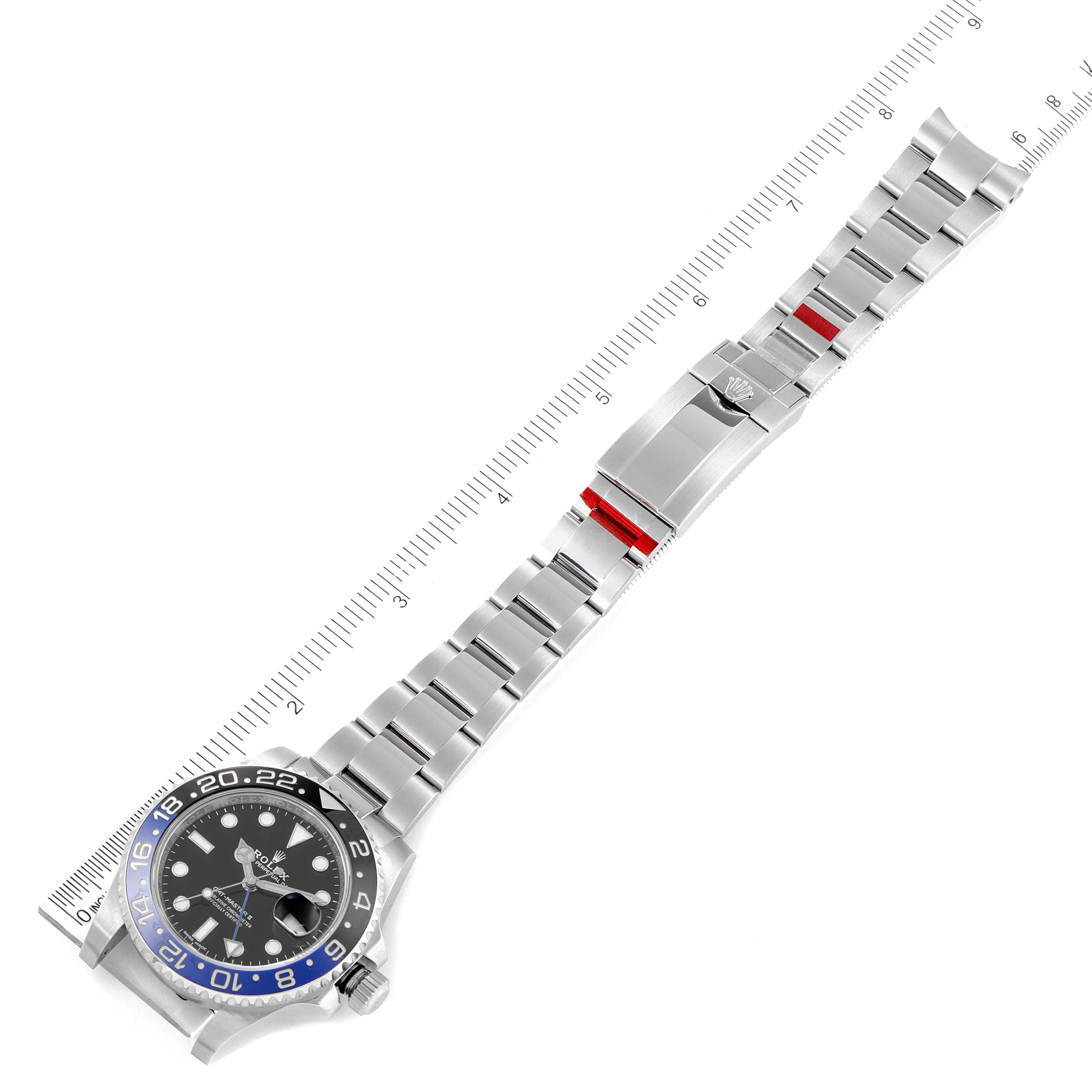 The image shows a top-down view of a Rolex GMT-Master 116710BLNR Men's Stainless Steel Black Dial 116710BLNR Men's Stainless Steel Black Dial watch with a visible bezel, dial, bracelet, and clasp, alongside a ruler.