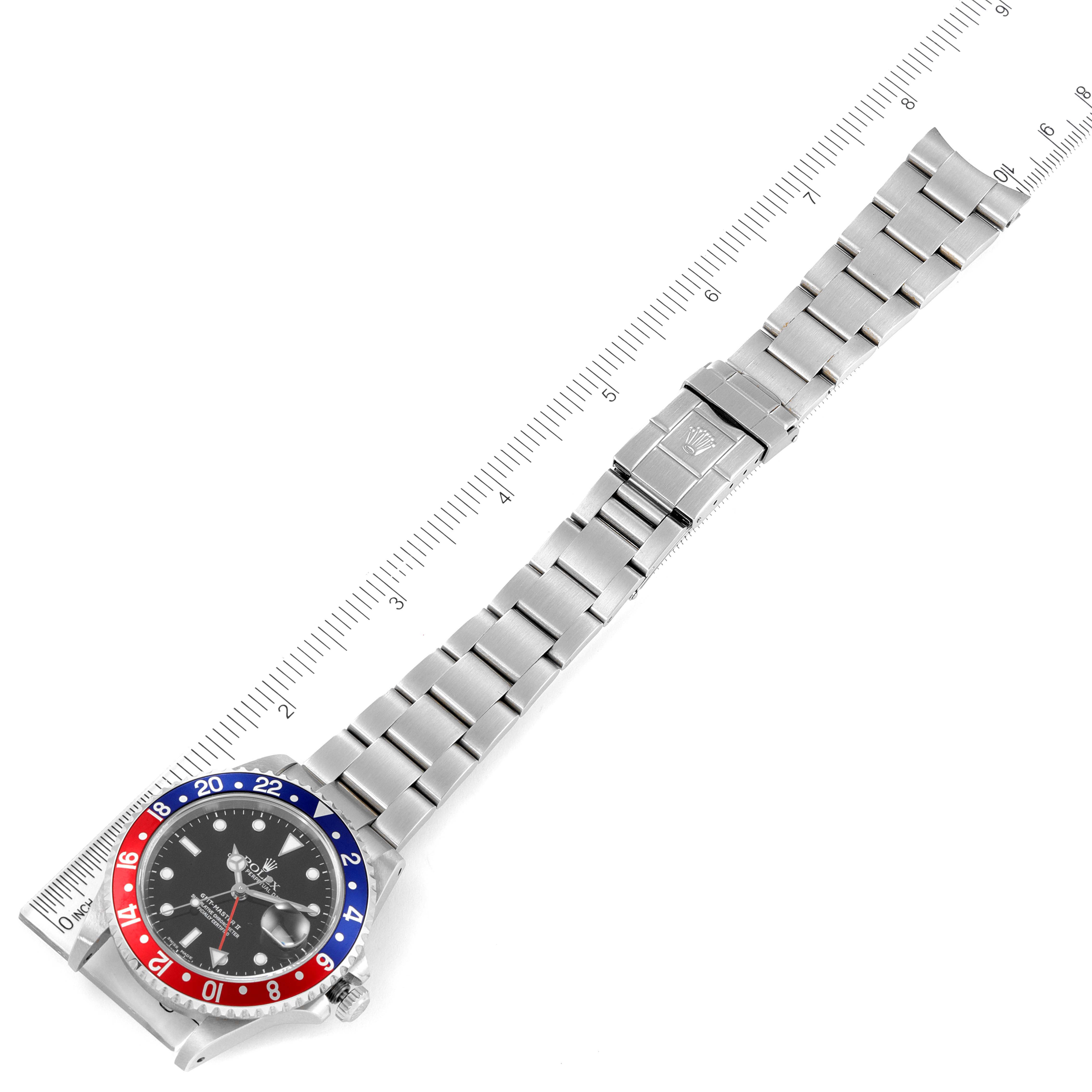 The image shows a top view of a Rolex GMT-Master 16710 Men
s Stainless Steel Black Dial 16710 Men
s Stainless Steel Black Dial watch, displaying its entire metal bracelet, clasp, and bezel.