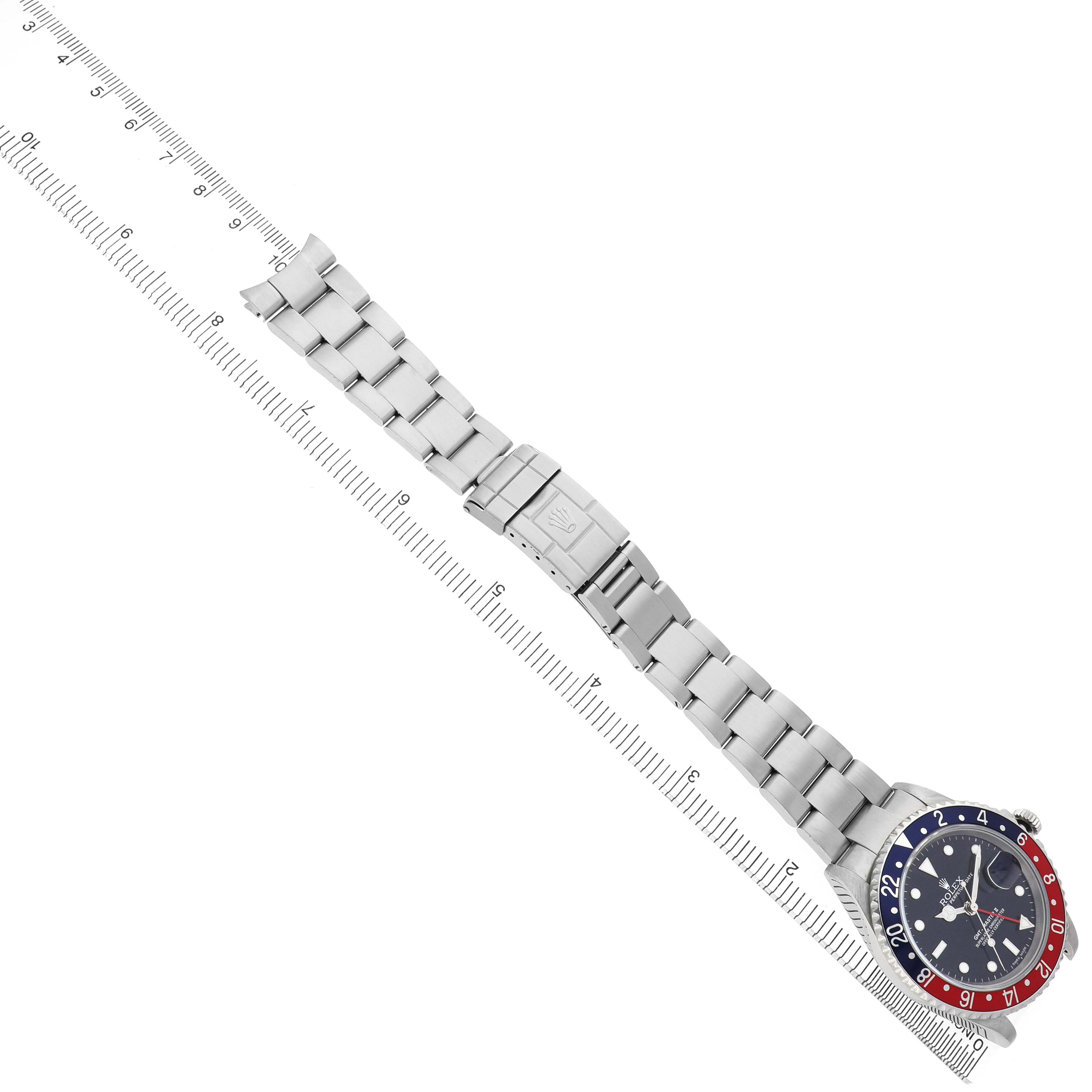 The Rolex GMT-Master 16710 Men's Stainless Steel Black Dial watch is displayed from a top-down angle, showing the face and full metal bracelet alongside a measuring ruler.