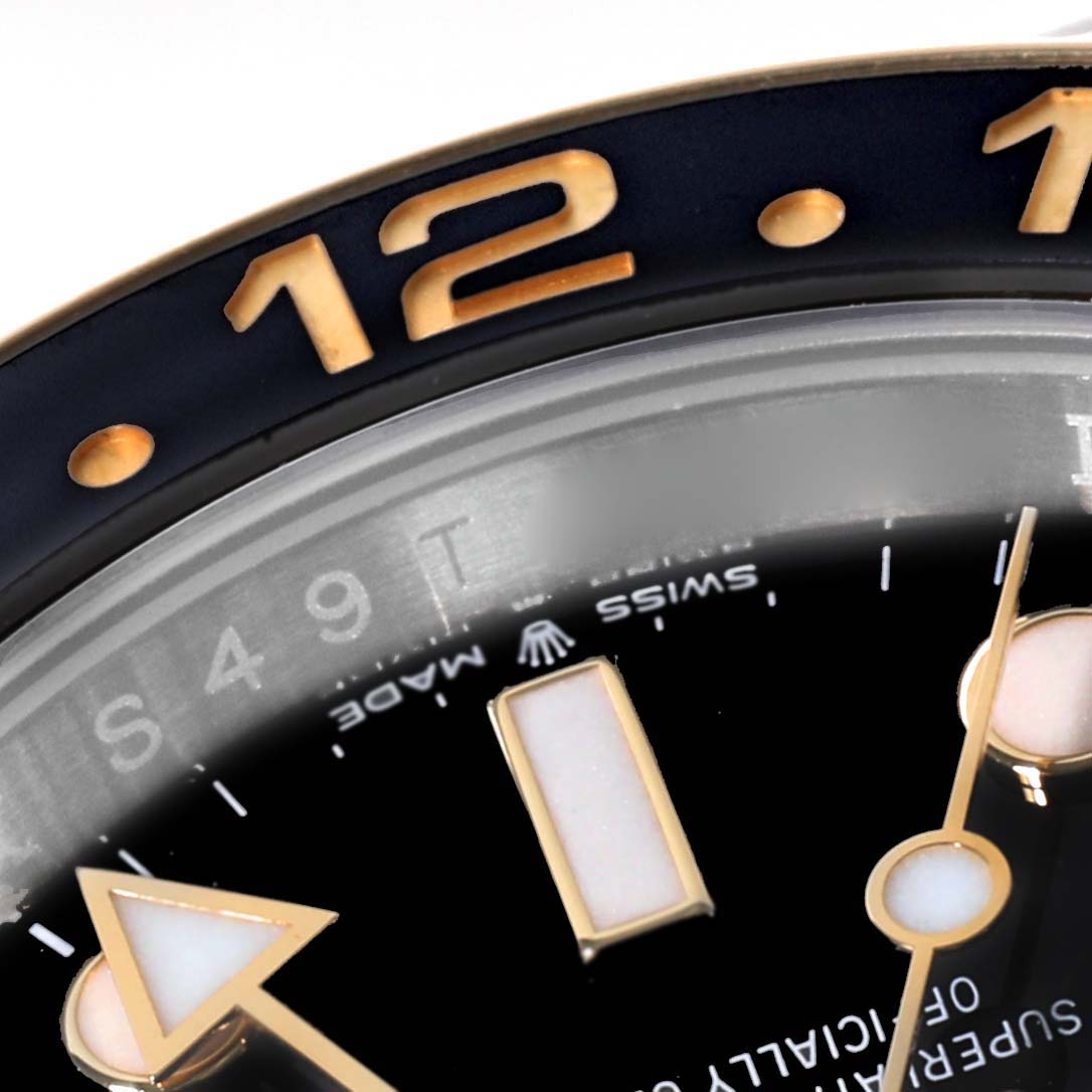 This is a close-up of the bezel, part of the dial, and the GMT hand of the Rolex GMT-Master 126713 Men's Steel and Gold (two tone) Black Dial 126713 Men's Steel and Gold (two tone) Black Dial model.