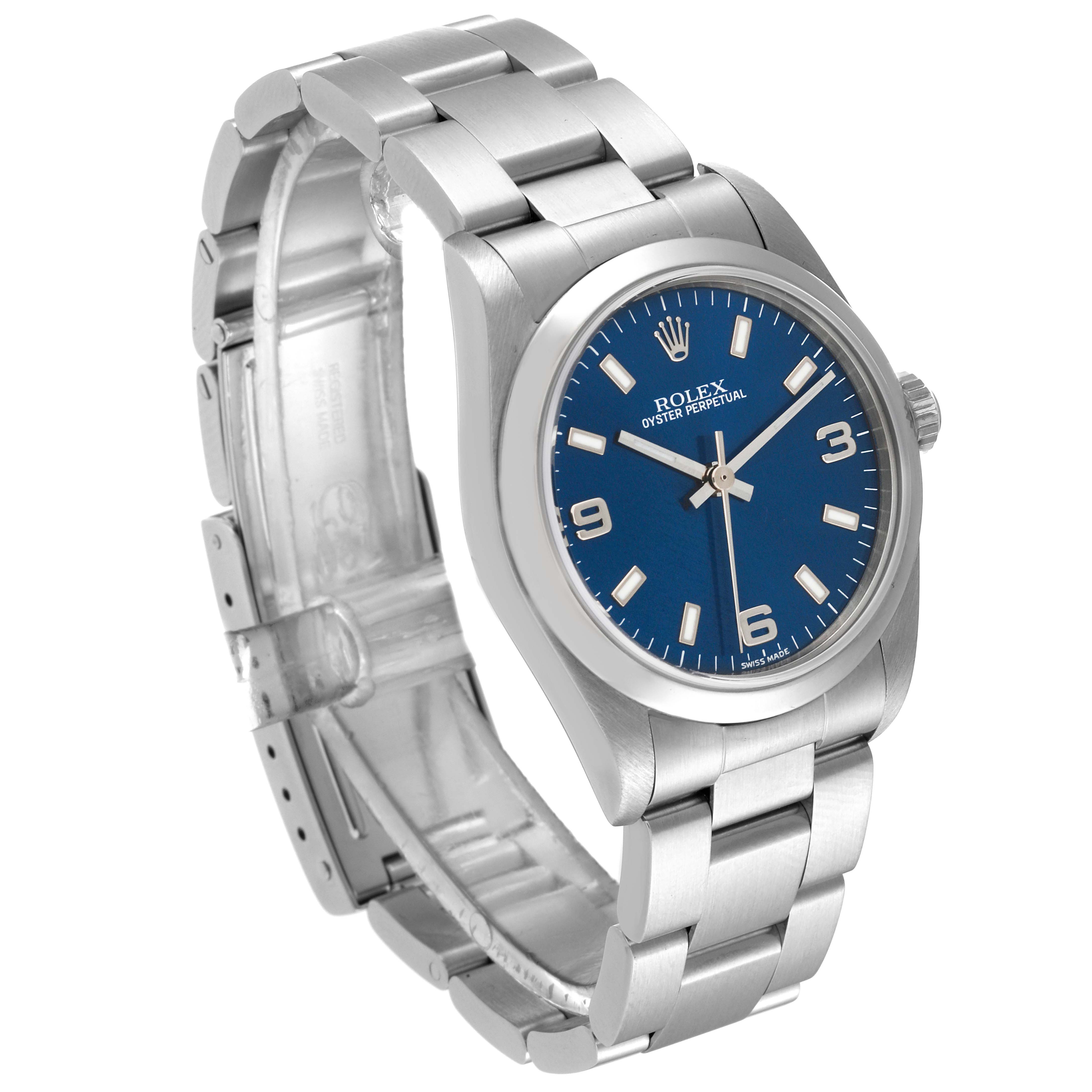 This Rolex Mid-Size 77080 Women's Stainless Steel Blue Dial 77080 Women's Stainless Steel Blue Dial Oyster Perpetual watch is shown at a three-quarter angle detailing the blue dial, bezel, case, and partially opened bracelet.