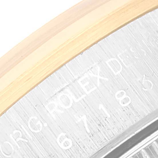 This close-up image shows the engraved edge of the case back of a Rolex Oyster Perpetual 67183 Women's Steel and Gold (two tone) Champagne Dial 67183 Women's Steel and Gold (two tone) Champagne Dial watch.