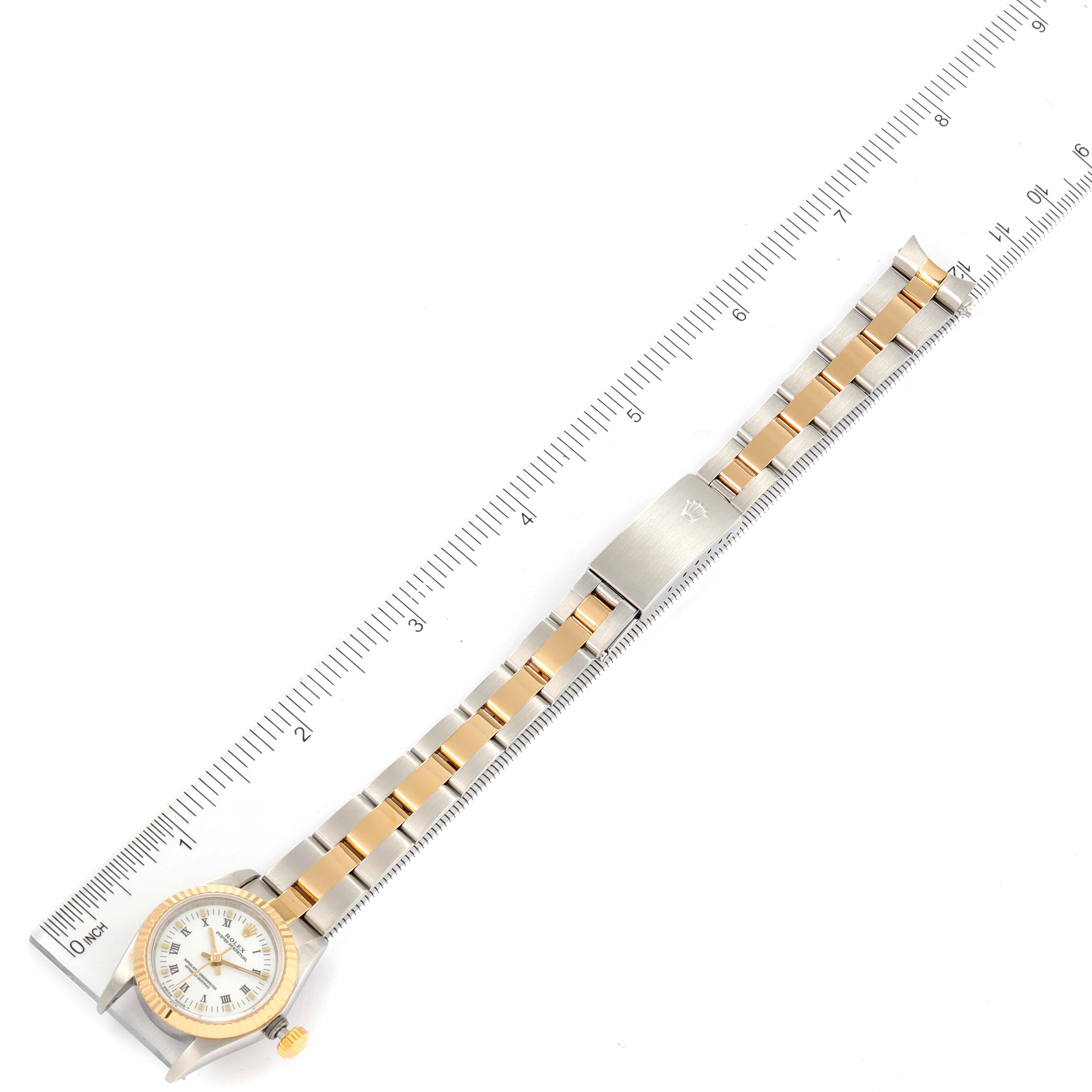 The image shows a Rolex Oyster Perpetual 67193 Women's Steel and Gold (two tone) White Dial 67193 Women's Steel and Gold (two tone) White Dial watch laid flat with a ruler for scale, focusing on the band and face.