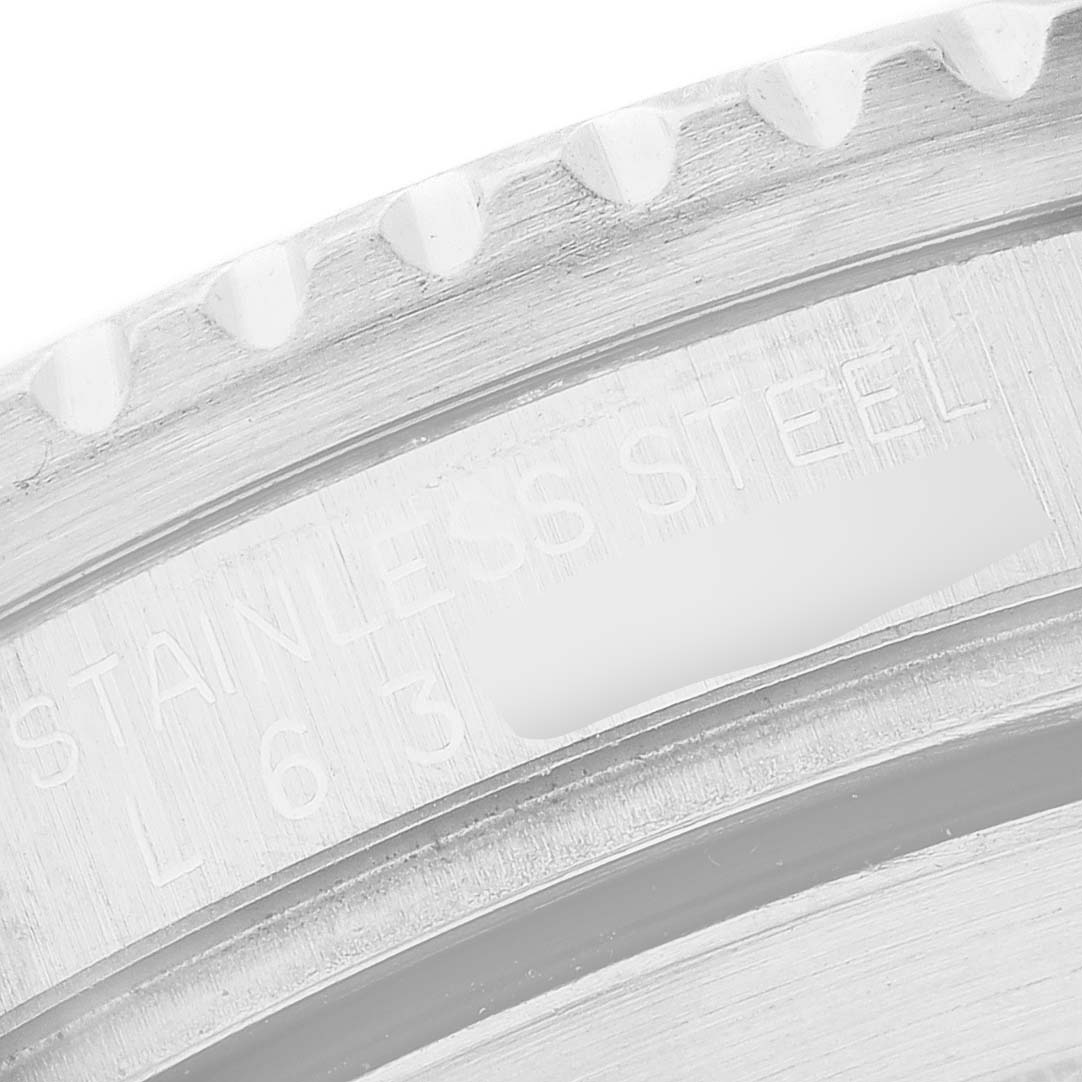 The image shows a close-up of the engraved inner bezel of a Rolex Submariner 16610 Men's Stainless Steel Black Dial, displaying the "STAINLESS STEEL" text.