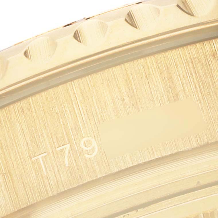 This close-up image shows part of the bezel and case of a Rolex Yacht-Master 69628 Women's Yellow Gold Mother of Pearl Dial 69628 Women's Yellow Gold Mother of Pearl Dial watch, focusing on the engraved serial number.