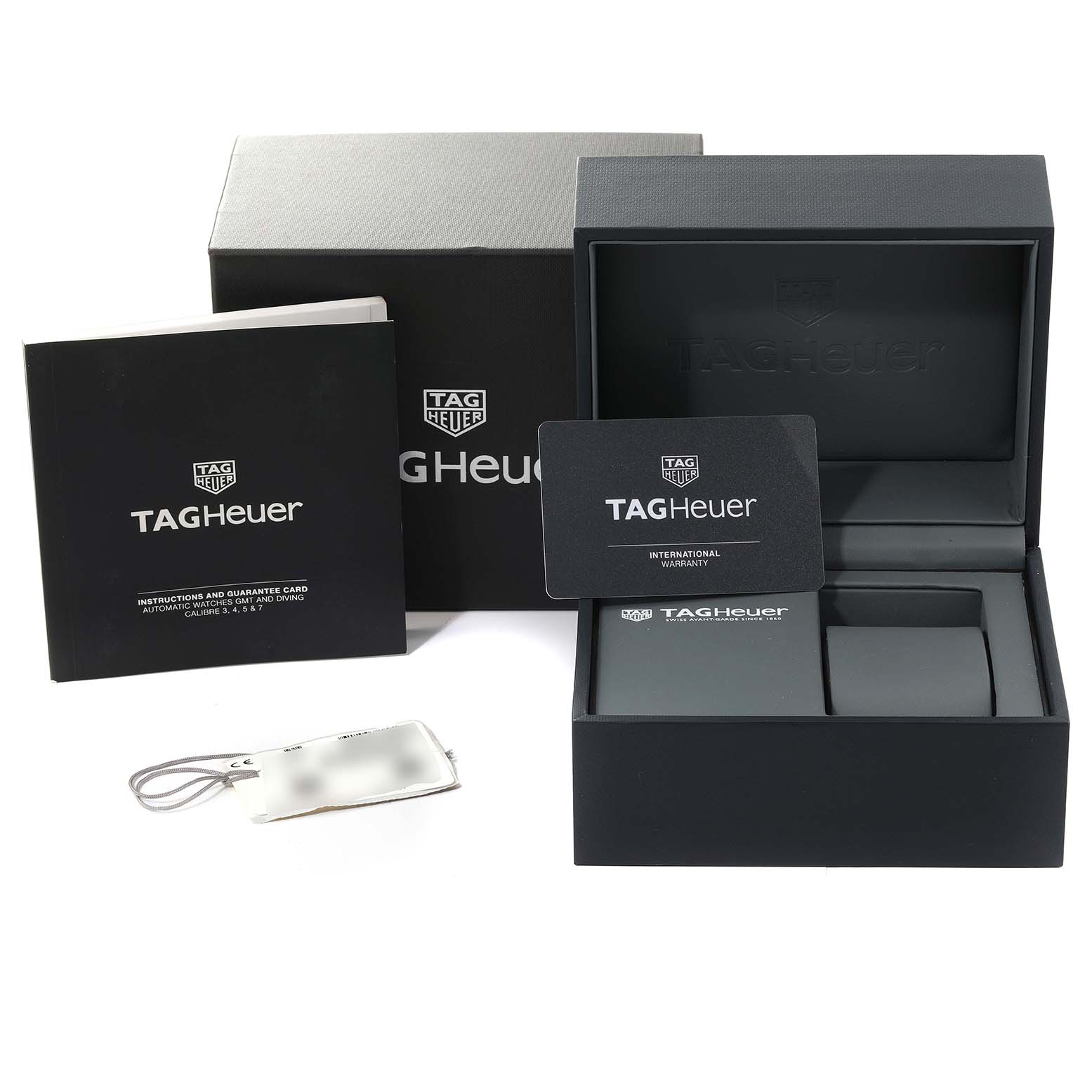 This image shows the Tag Heuer Aquaracer WAY201S Men's Stainless Steel Green Dial WAY201S Men's Stainless Steel Green Dial watch box, warranty card, instruction booklet, and tag from a frontal angle.