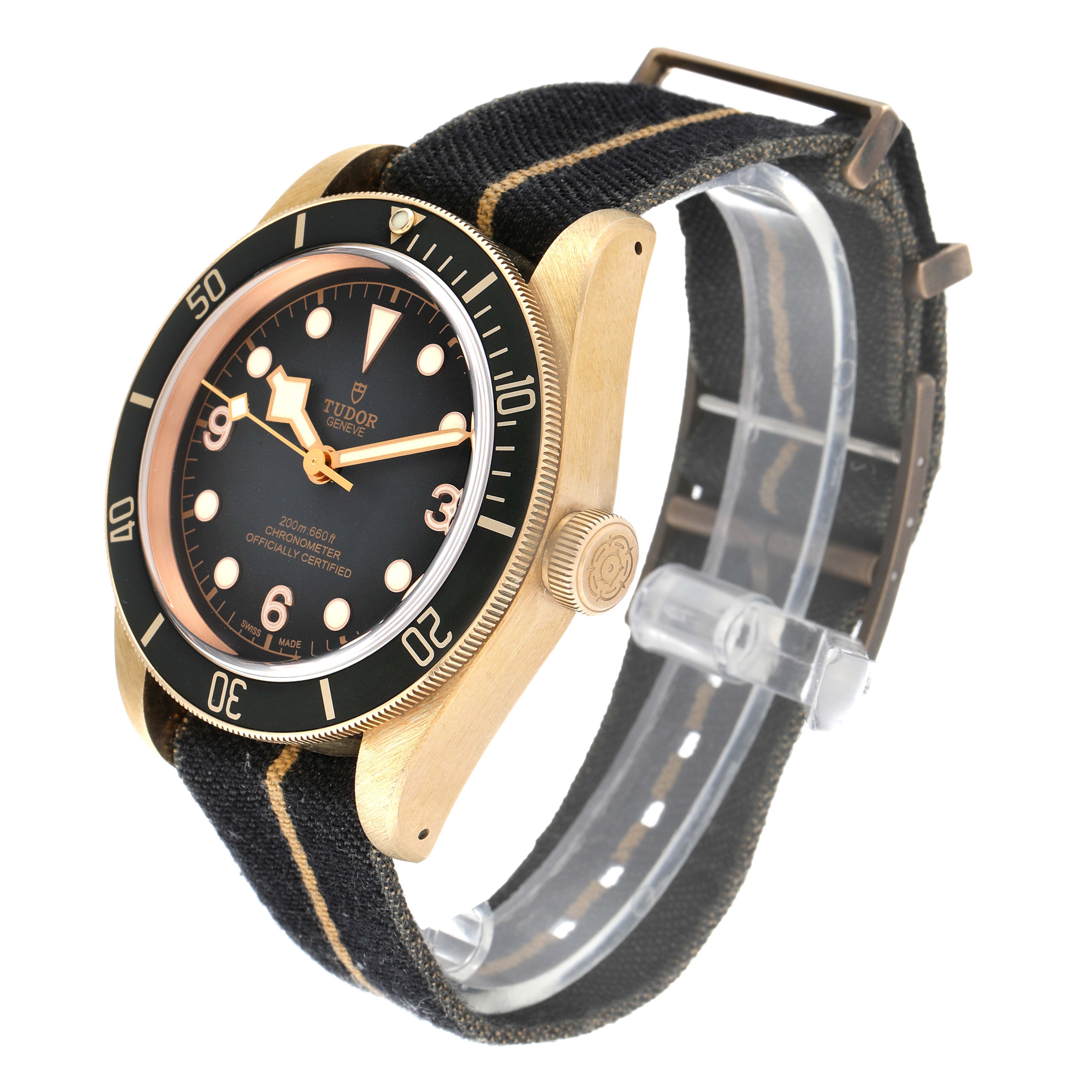 The Tudor Heritage Black Bay 79250B Men's Bronze Black Dial 79250B Men's Bronze Black Dial watch is shown at a three-quarter angle, highlighting its black dial, bronze case, and fabric strap.