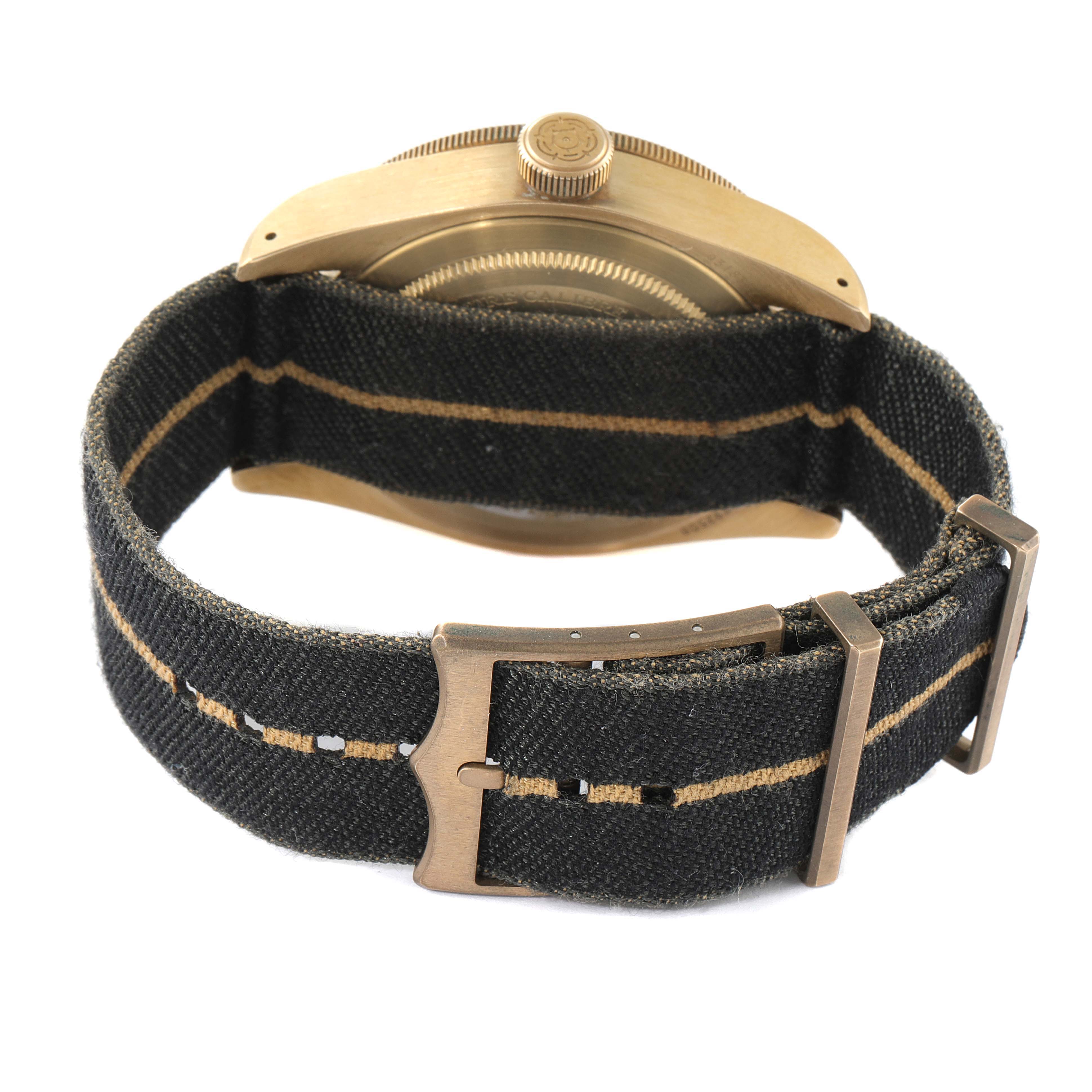 This image shows the back of a Tudor Heritage Black Bay 79250B Men's Bronze Black Dial 79250B Men's Bronze Black Dial watch with a black fabric strap and bronze clasp.