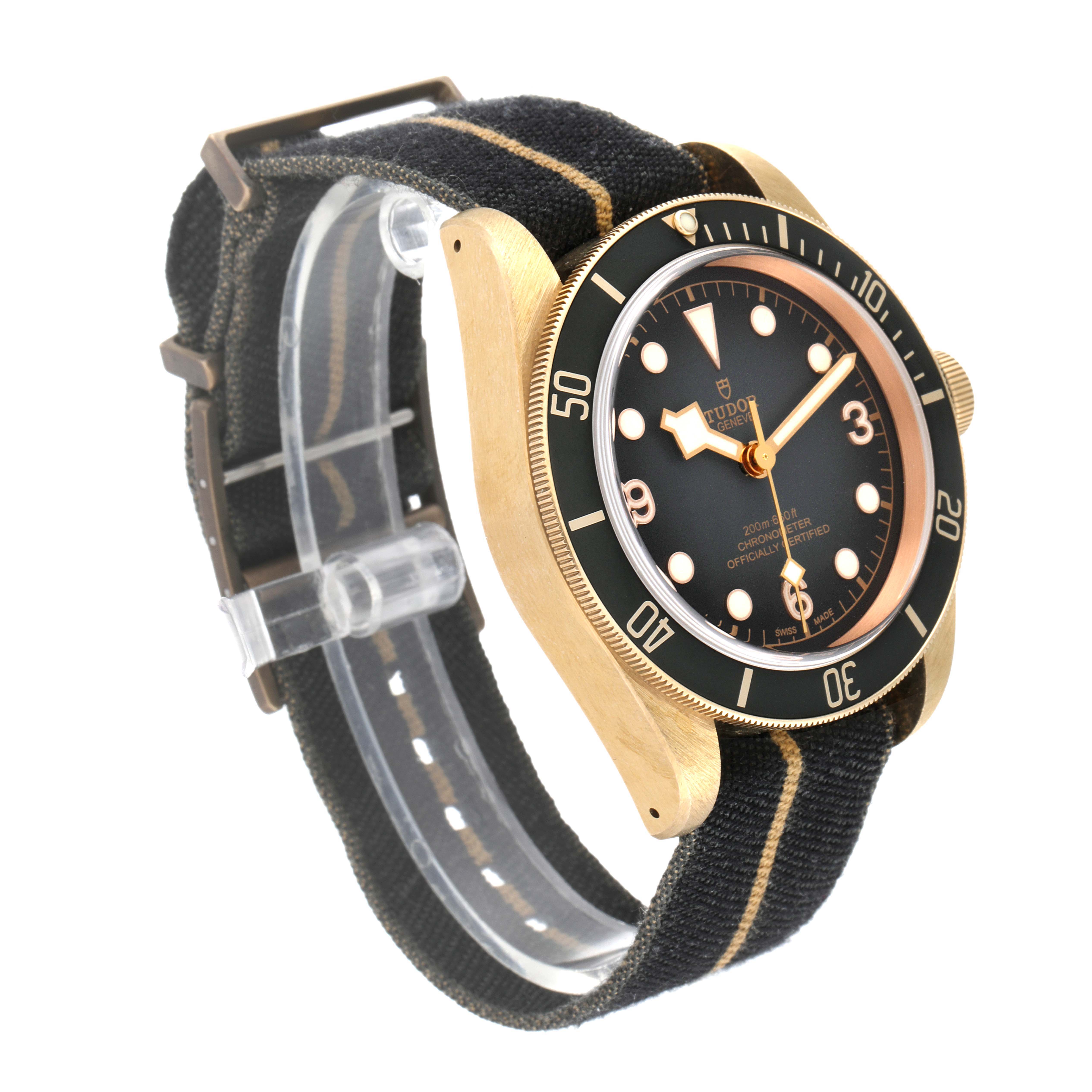 The Tudor Heritage Black Bay 79250B Men's Bronze Black Dial 79250B Men's Bronze Black Dial watch is shown from a three-quarter angle, highlighting its face, bezel, case, and fabric strap.