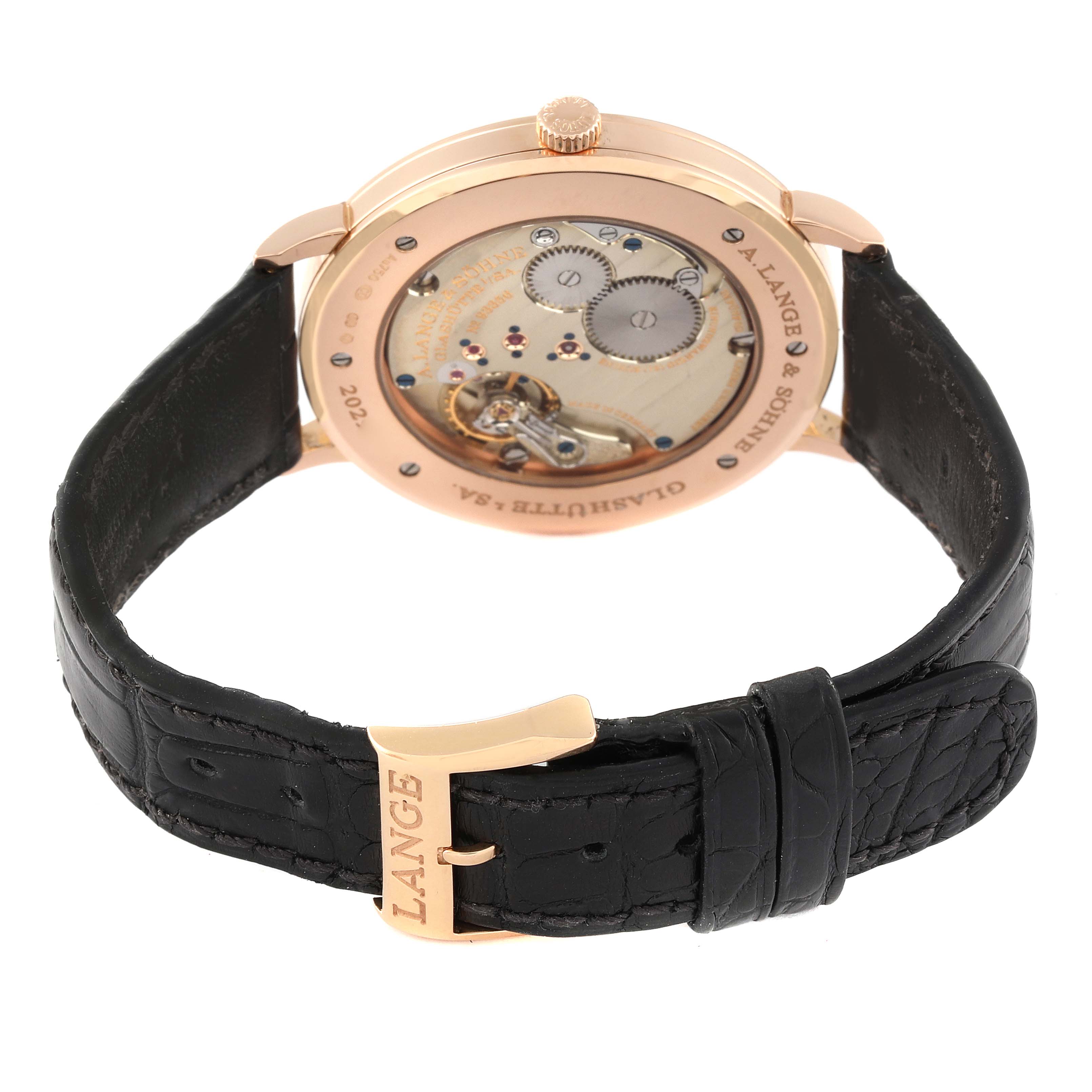 The image shows the back view of the A. Lange & Sohne Saxonia 211.032 Men's Rose Gold Silver Dial model watch, highlighting its movement and black leather strap.