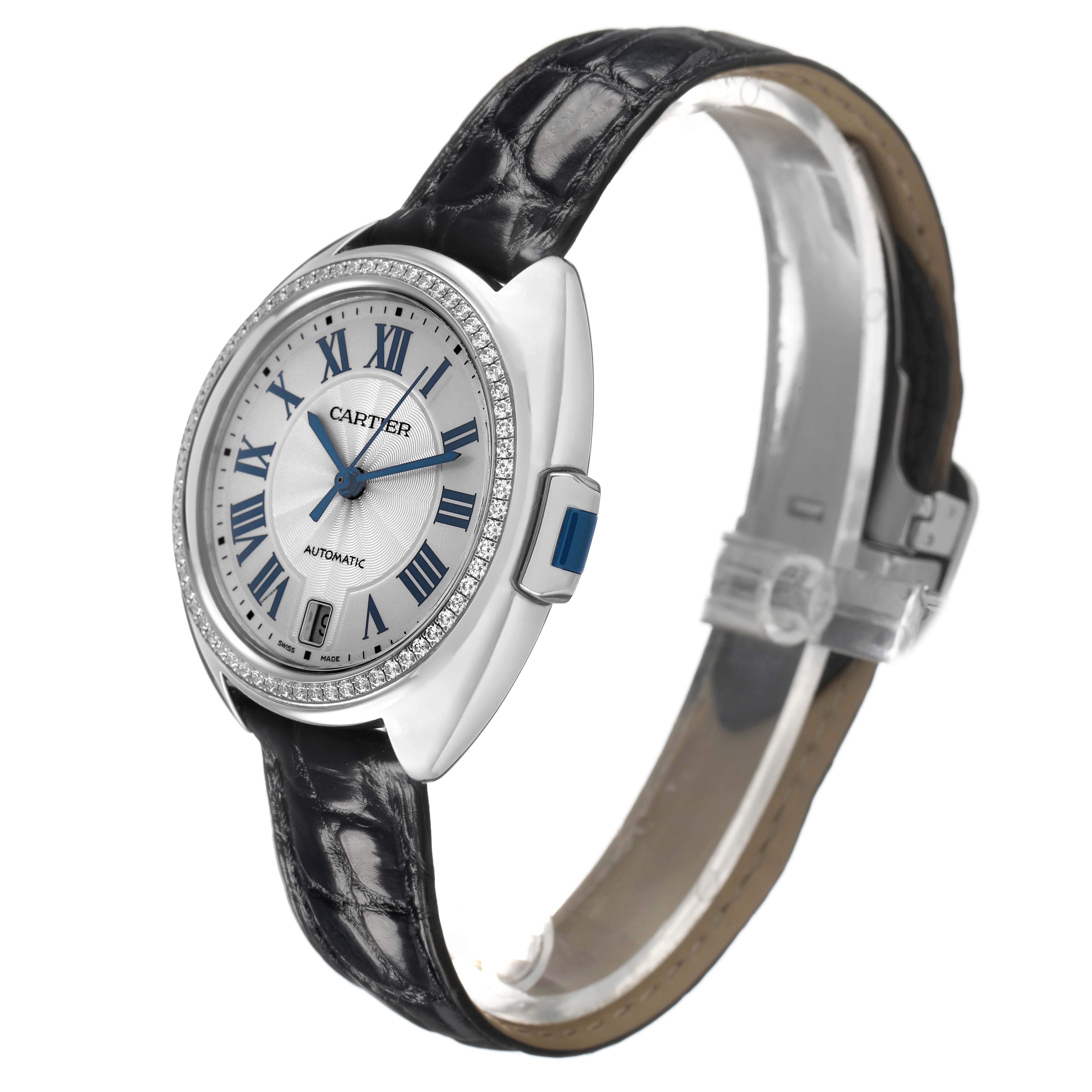 The Cartier Clé watch is shown at a three-quarter angle, displaying the face, bezel, and strap in detail.