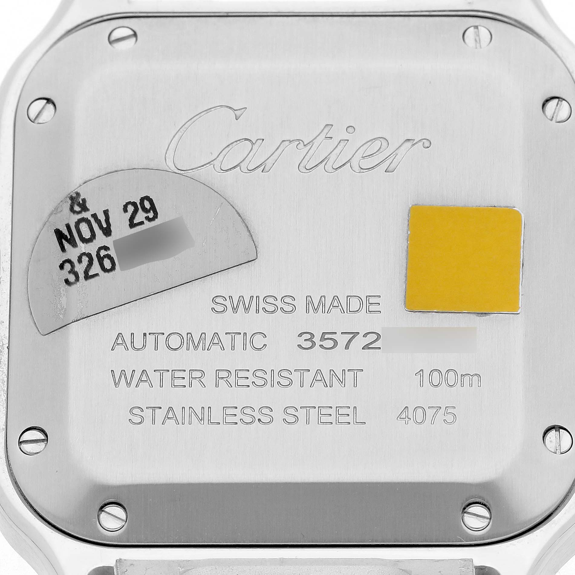 The image shows the back case of a Santos model by Cartier, highlighting engravings and screw details.