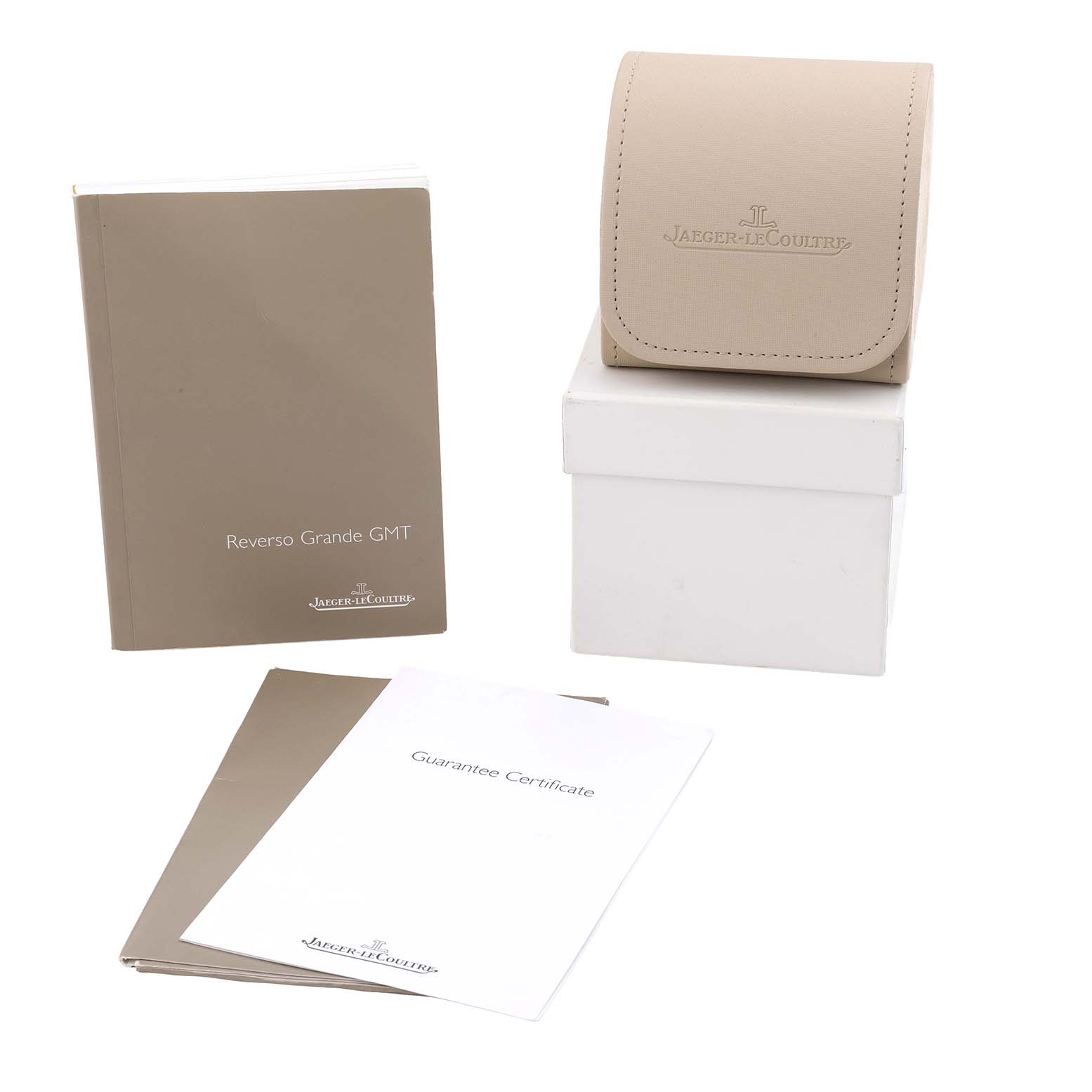 The image shows accessories for a Jaeger-LeCoultre Reverso watch, including a watch case, manuals, and a guarantee certificate.