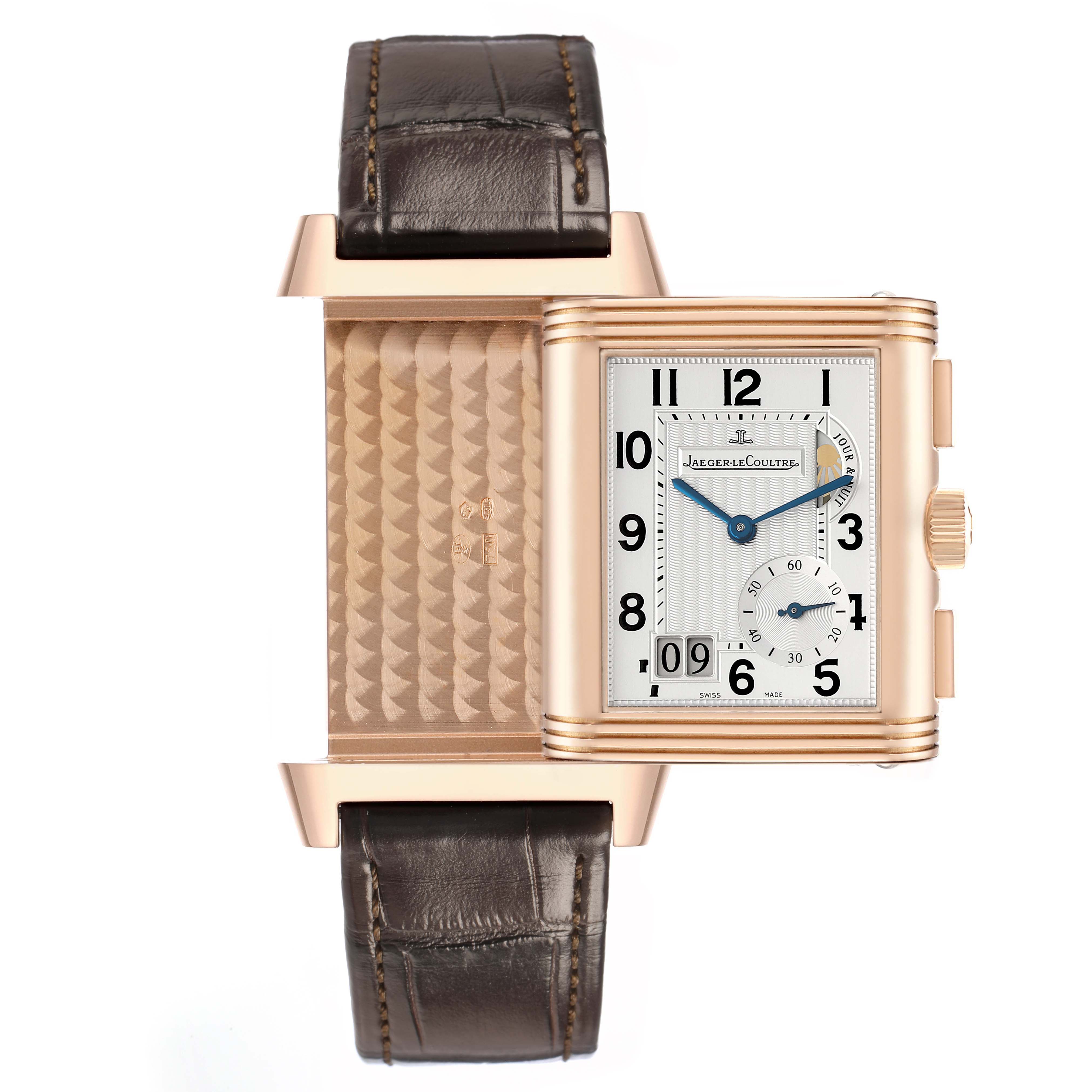 The Jaeger-LeCoultre Reverso watch is shown partially flipped, revealing both its face and the intricate case back.