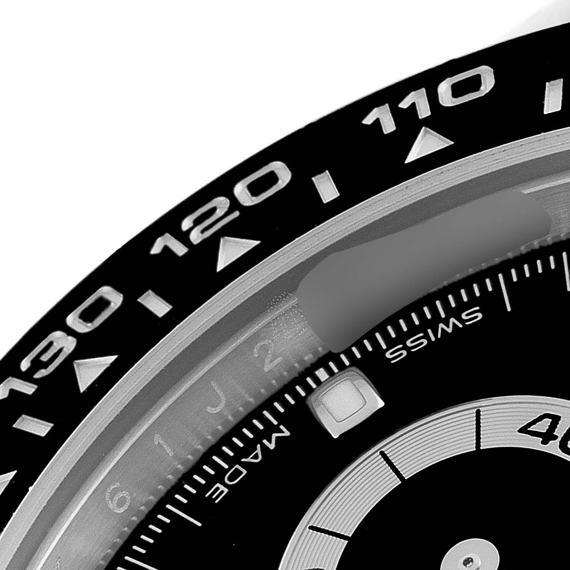 The image shows a close-up of the bezel and part of the dial of a Rolex Daytona 116500 Men's Stainless Steel Black Dial 116500 Men's Stainless Steel Black Dial watch.