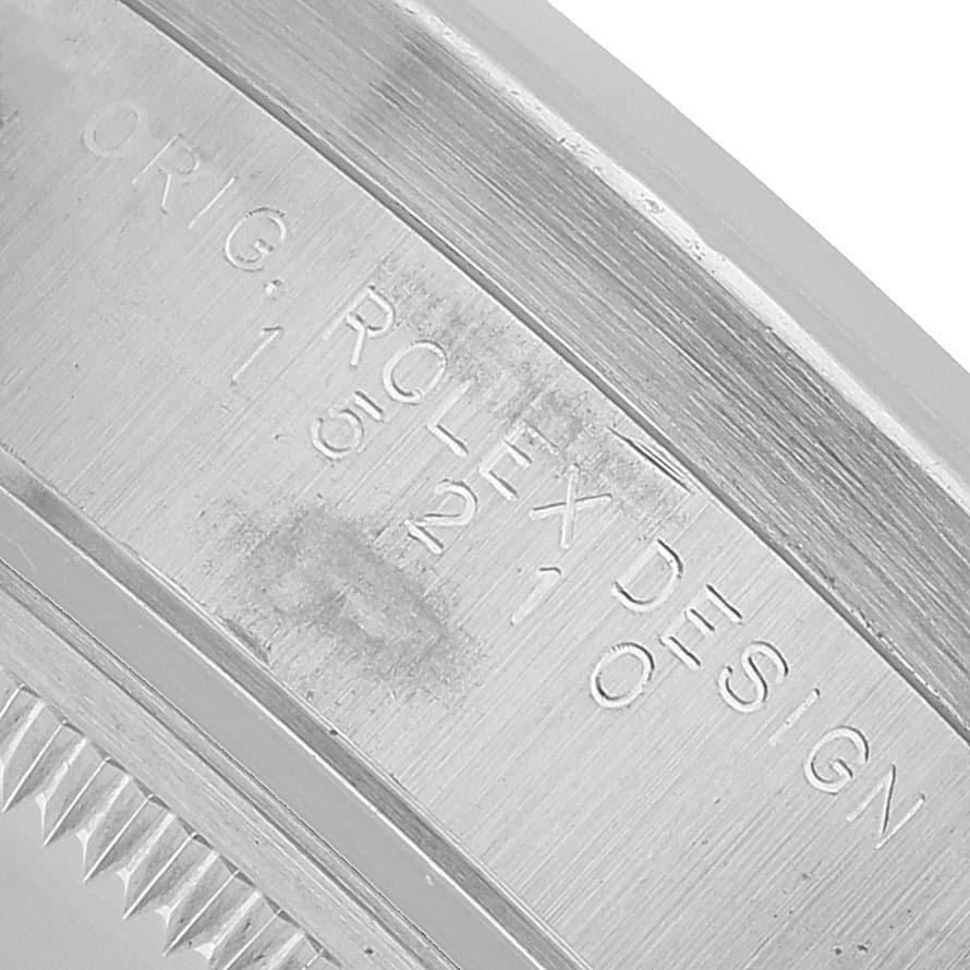 The image shows an engraved side view of a Rolex Date 15210 Men's Stainless Steel Blue Dial model, highlighting the bezel and serial number.