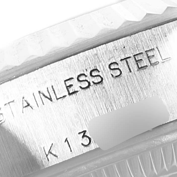 This image shows a close-up of the stainless steel engraving and the fluted bezel on a Rolex Datejust 79174 Women's Stainless Steel Black Dial 79174 Women's Stainless Steel Black Dial watch.