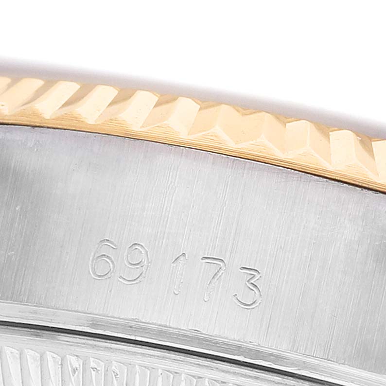 The image shows a close-up of the Rolex Datejust 69173 Women's Steel and Gold (two tone) Champagne Dial model's fluted bezel and the engraved serial number on the watch case.