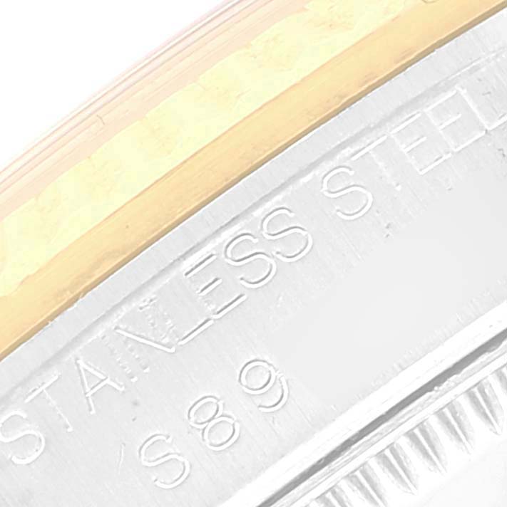 The image shows a close-up of the "STAINLESS STEEL" engraving on the edge of the bezel and case of a Rolex Mid-Size 68273 Women's Steel and Gold (two tone) Black Dial 68273 Women's Steel and Gold (two tone) Black Dial model watch.