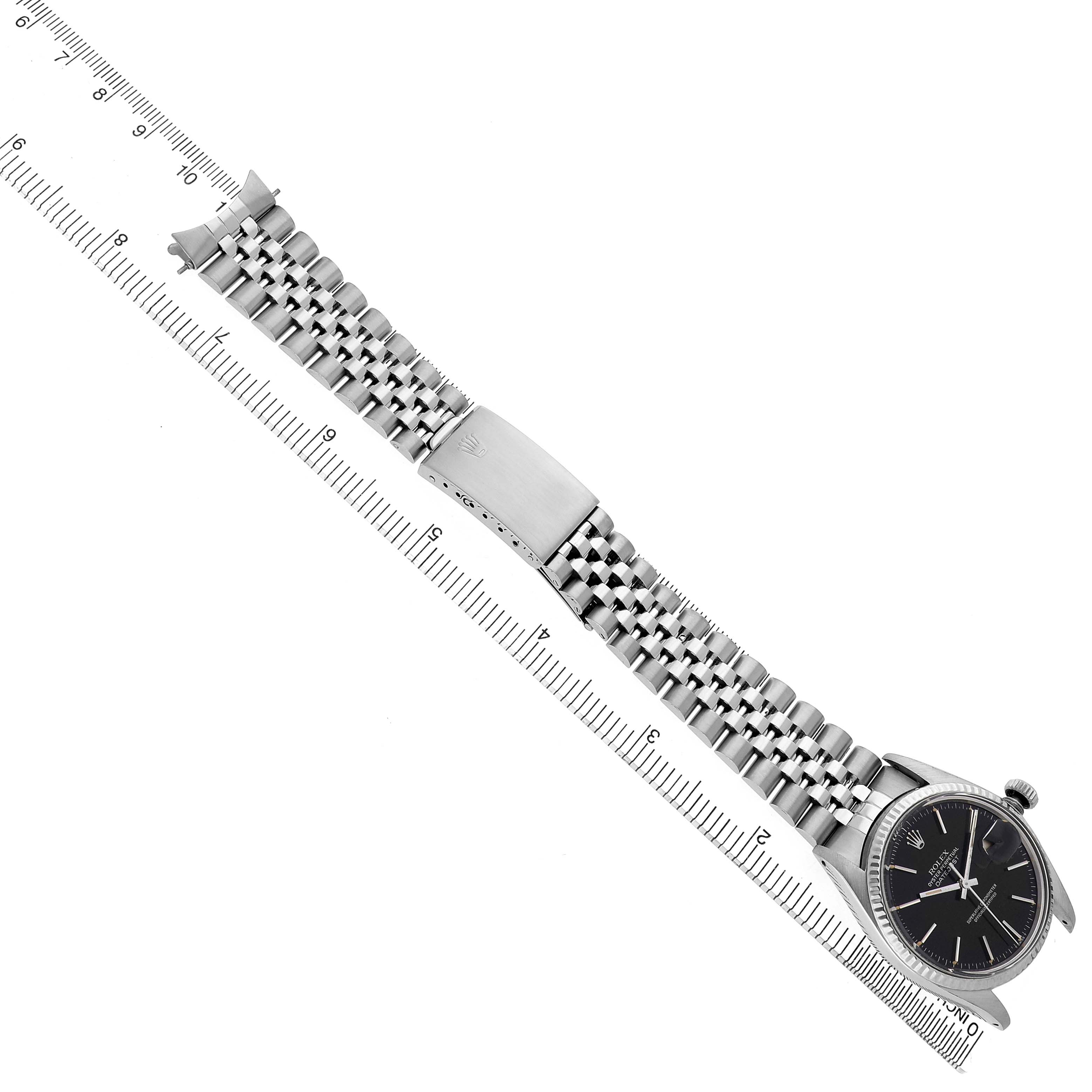 The Rolex Datejust 16014 Men's Stainless Steel Black Dial watch is displayed horizontally, showing the face, jubilee bracelet, and clasp alongside a ruler for scale.