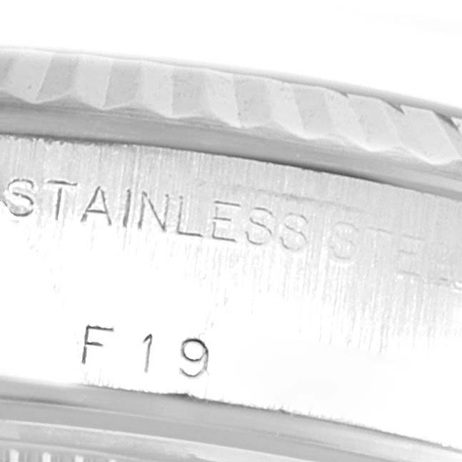 The image shows a close-up of the engraved bezel and case back of a Rolex Datejust 79174 Women
s Stainless Steel Silver Dial 79174 Women
s Stainless Steel Silver Dial watch, highlighting the "STAINLESS STEEL" marking and "F19."