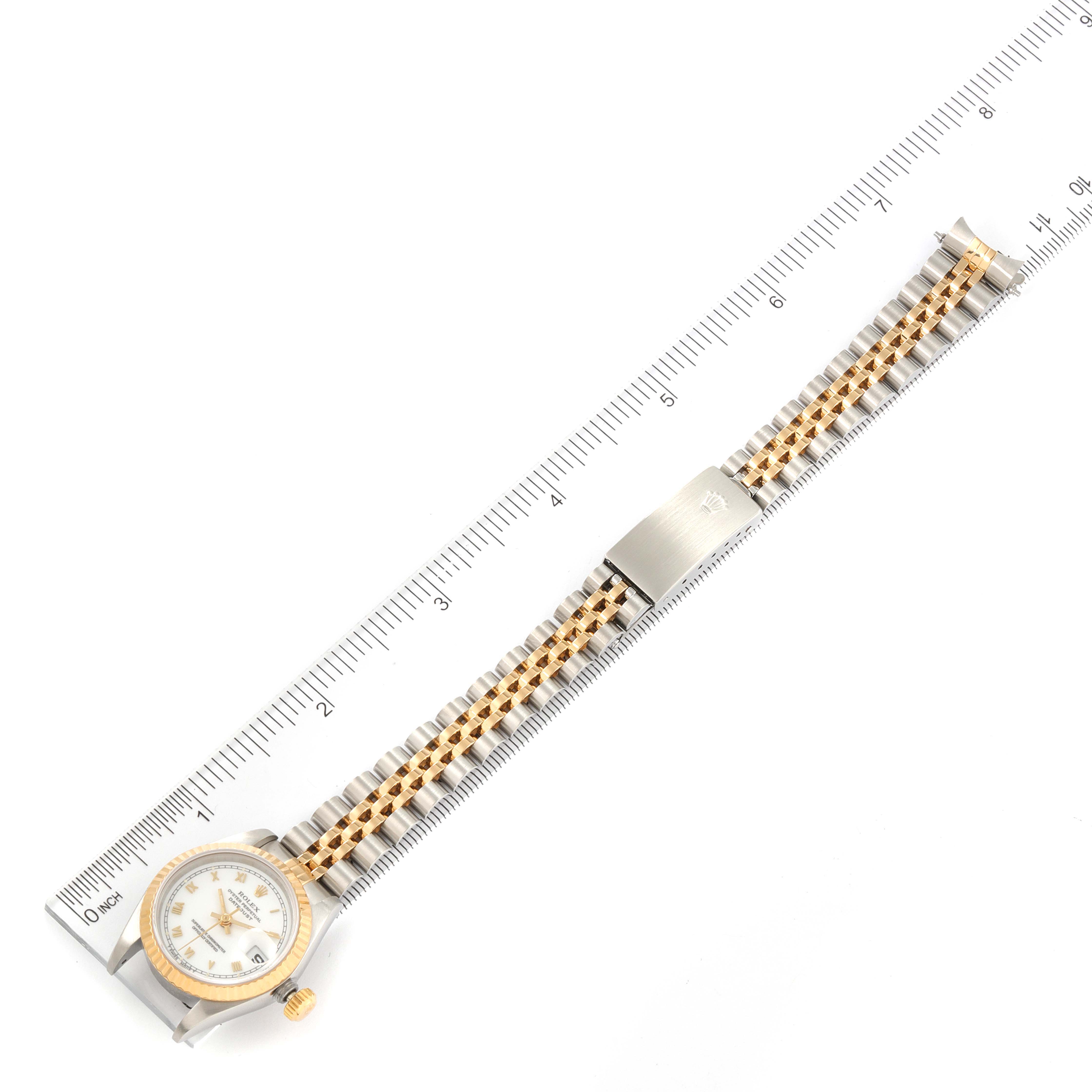 This is a top-down view of a Rolex Datejust 69173 Women's Steel and Gold (two tone) White Dial 69173 Women's Steel and Gold (two tone) White Dial model, showcasing the dial, bezel, crown, and bracelet against a ruler background.