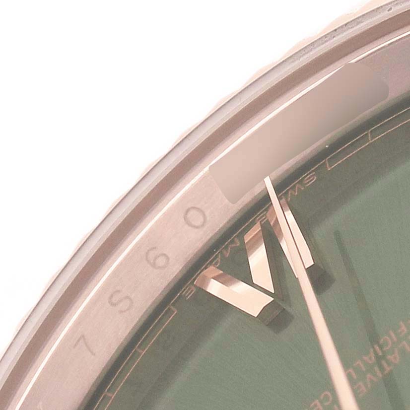 The image shows a close-up of a Rolex President 228235 Men's Rose Gold Green Dial model watch, highlighting the bezel, dial edge, and part of the hands.