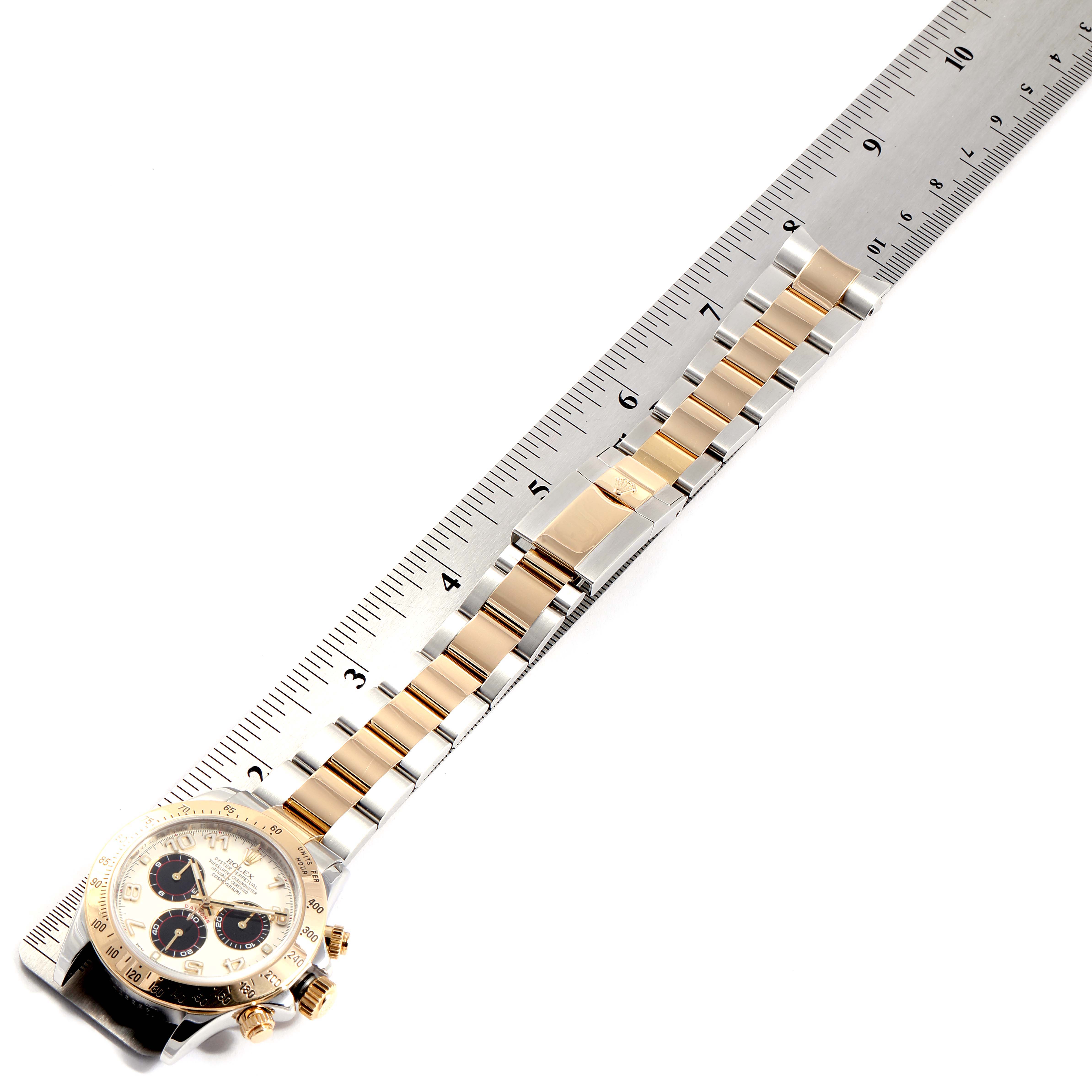 The image shows a Rolex Daytona 116523 Men's Steel and Gold (two tone) Silver Dial 116523 Men's Steel and Gold (two tone) Silver Dial watch with its band measured against a ruler, displaying both the watch face and bracelet.