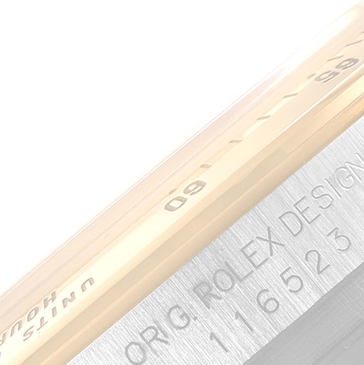 The image shows a close-up of the bezel and the edge of the case back of a Rolex Daytona 116523 Men
s Steel and Gold (two tone) Black Dial 116523 Men
s Steel and Gold (two tone) Black Dial watch.