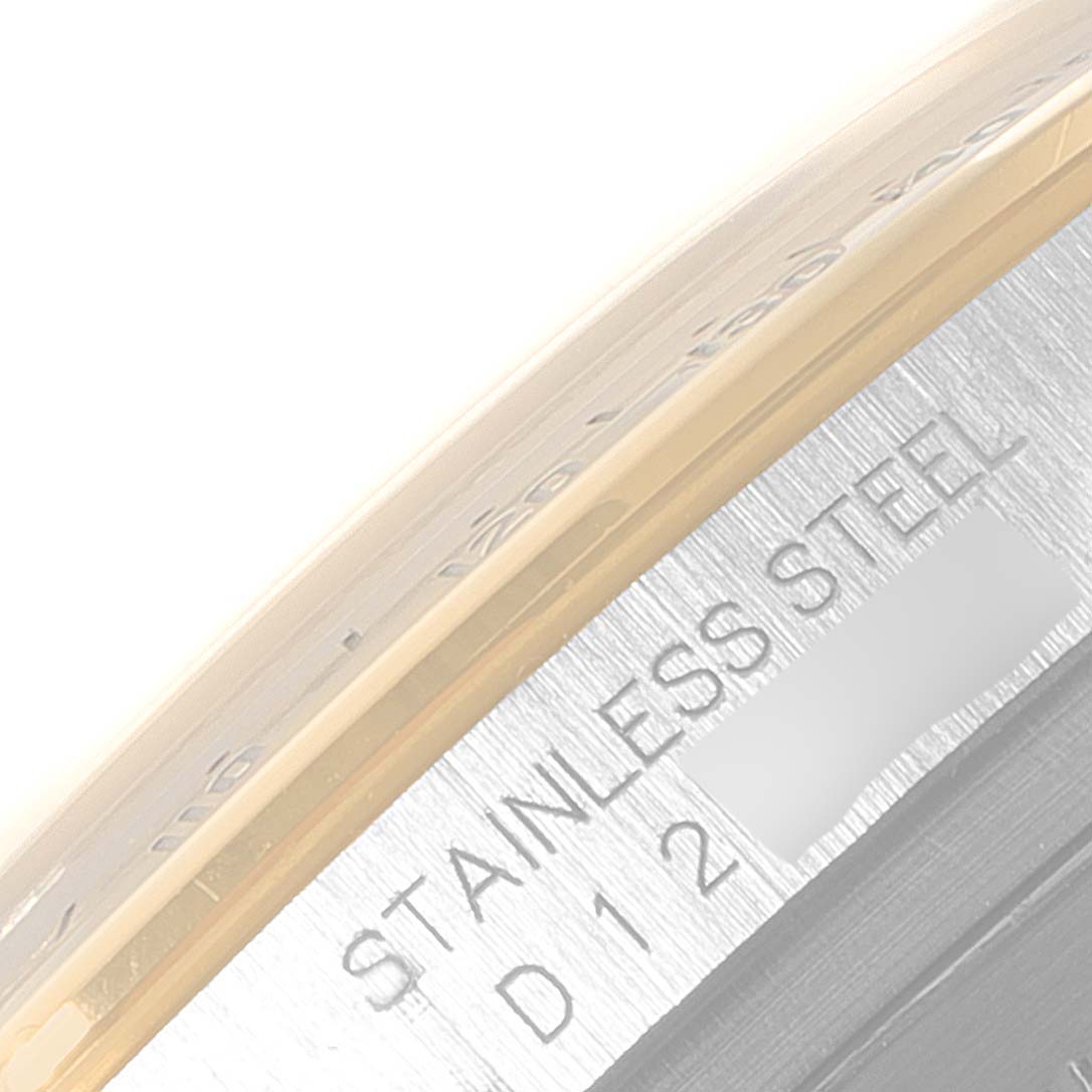 This close-up image shows part of the bezel and the "STAINLESS STEEL" engraved on the side of a Rolex Daytona 116523 Men
s Steel and Gold (two tone) Black Dial 116523 Men
s Steel and Gold (two tone) Black Dial watch.