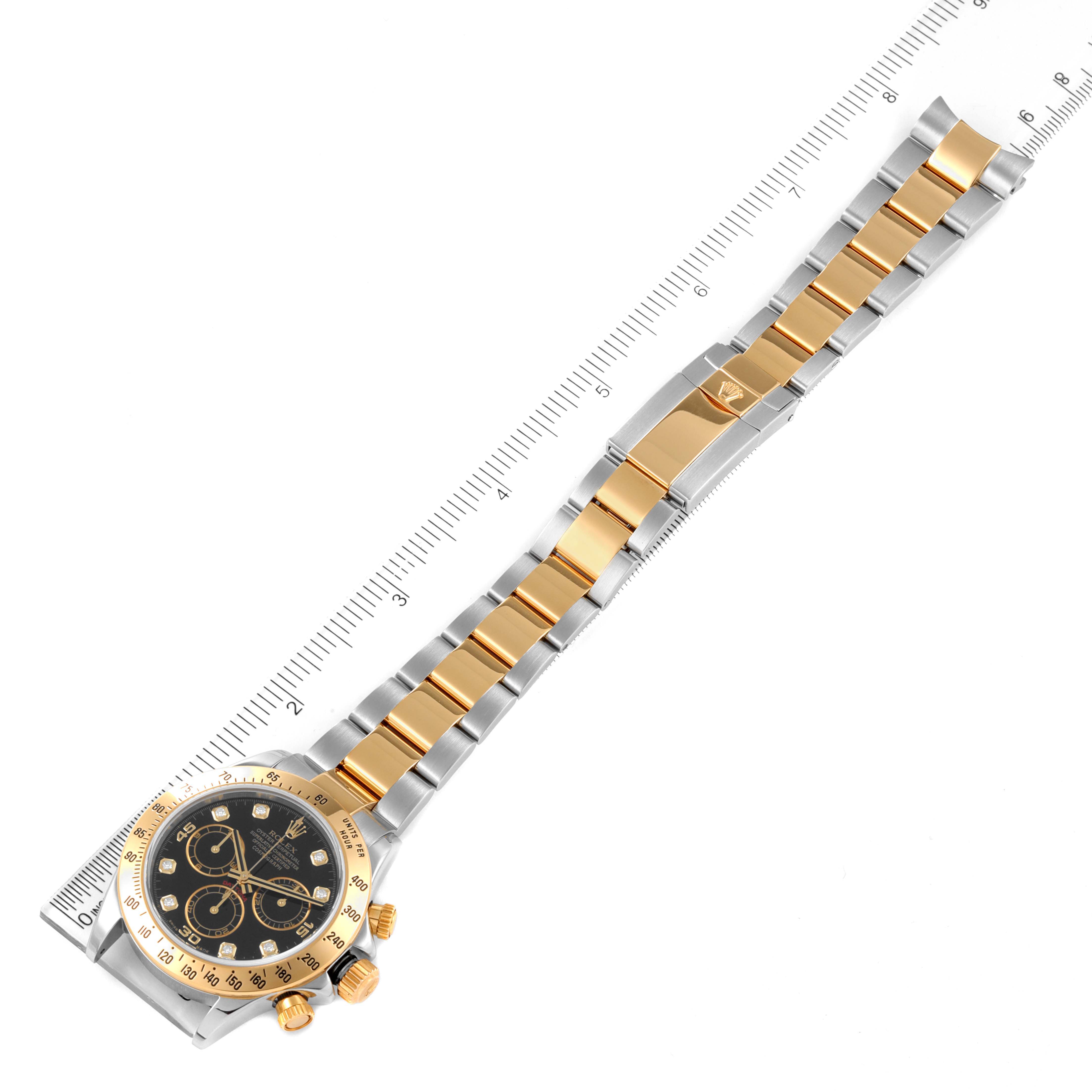 The watch is a Rolex Daytona 116523 Men
s Steel and Gold (two tone) Black Dial 116523 Men
s Steel and Gold (two tone) Black Dial model shown from a top view, featuring its gold and silver bracelet and face with rulers for scale.
