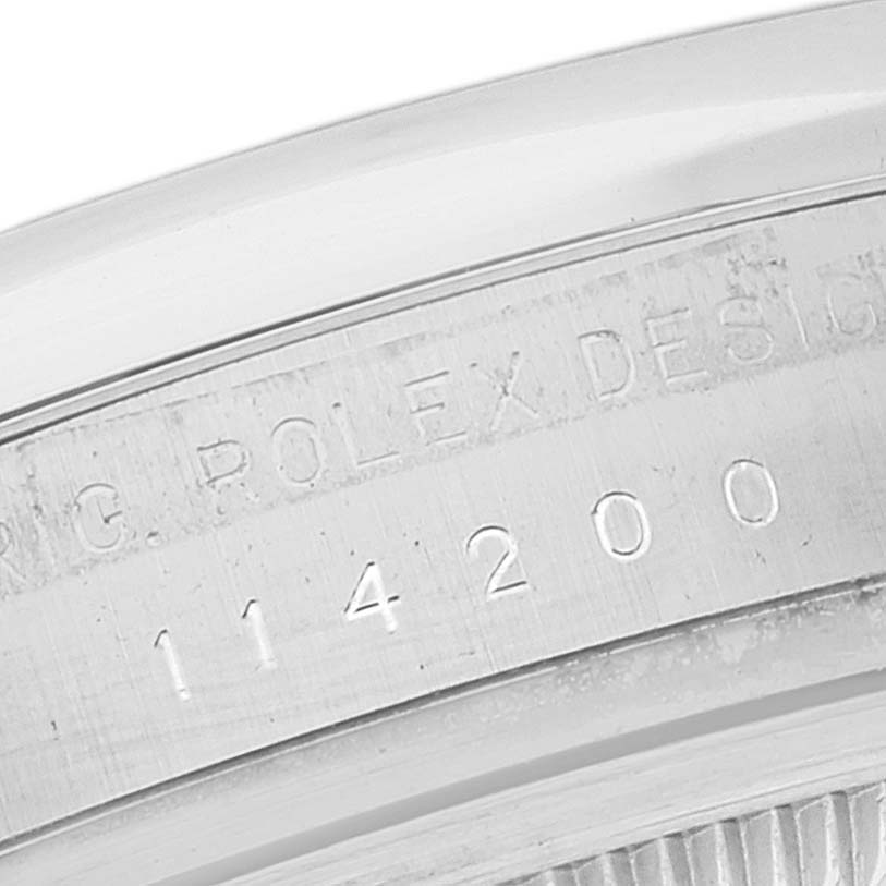 This image shows a close-up of the case back engraving of a Rolex Oyster Perpetual 114200 Men
s Stainless Steel Green Dial 114200 Men
s Stainless Steel Green Dial model, displaying the serial number.