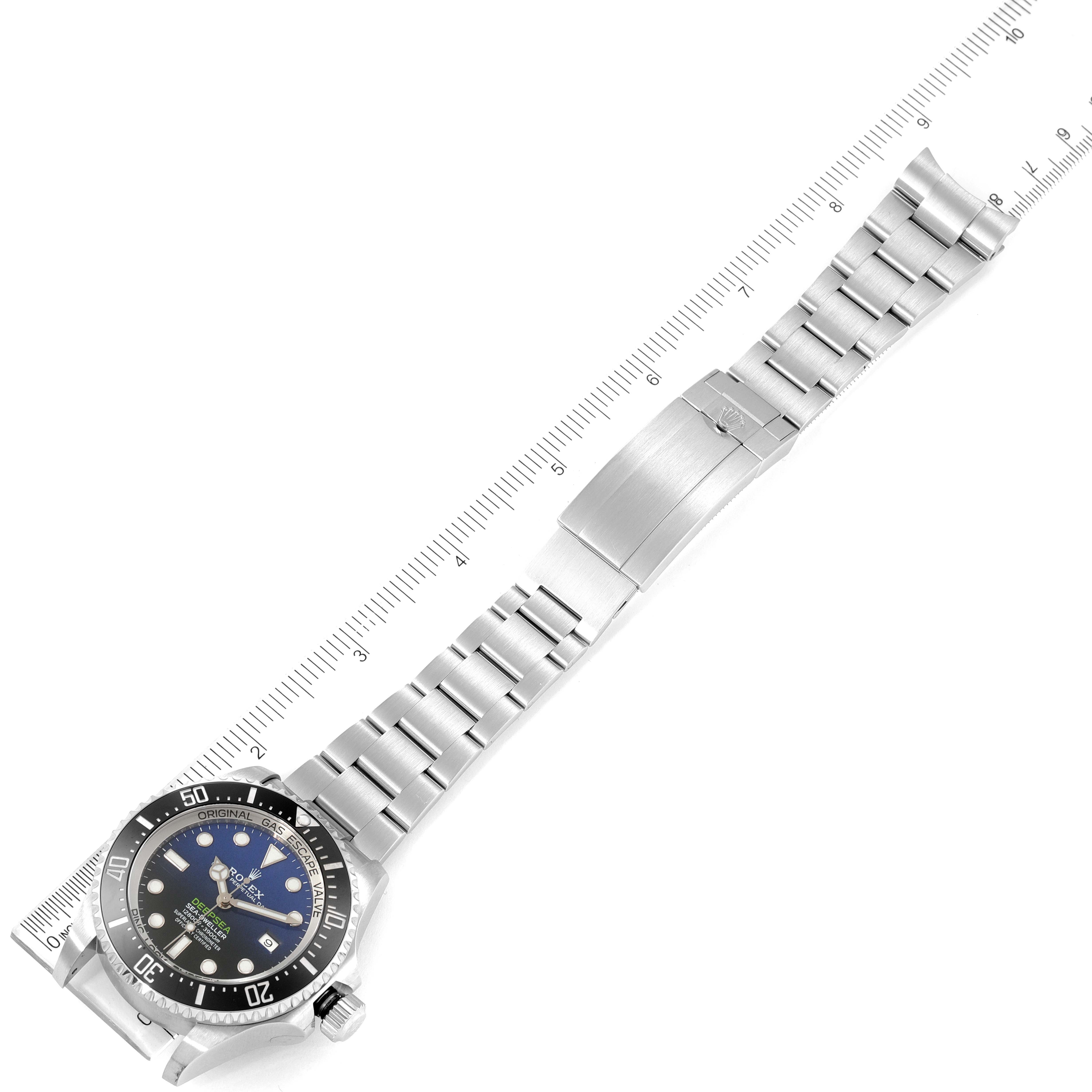 The image shows a top view of a Rolex Sea-Dweller 126660 Men's Stainless Steel Blue Dial 126660 Men's Stainless Steel Blue Dial watch with its stainless steel bracelet extended and aligned with a ruler.