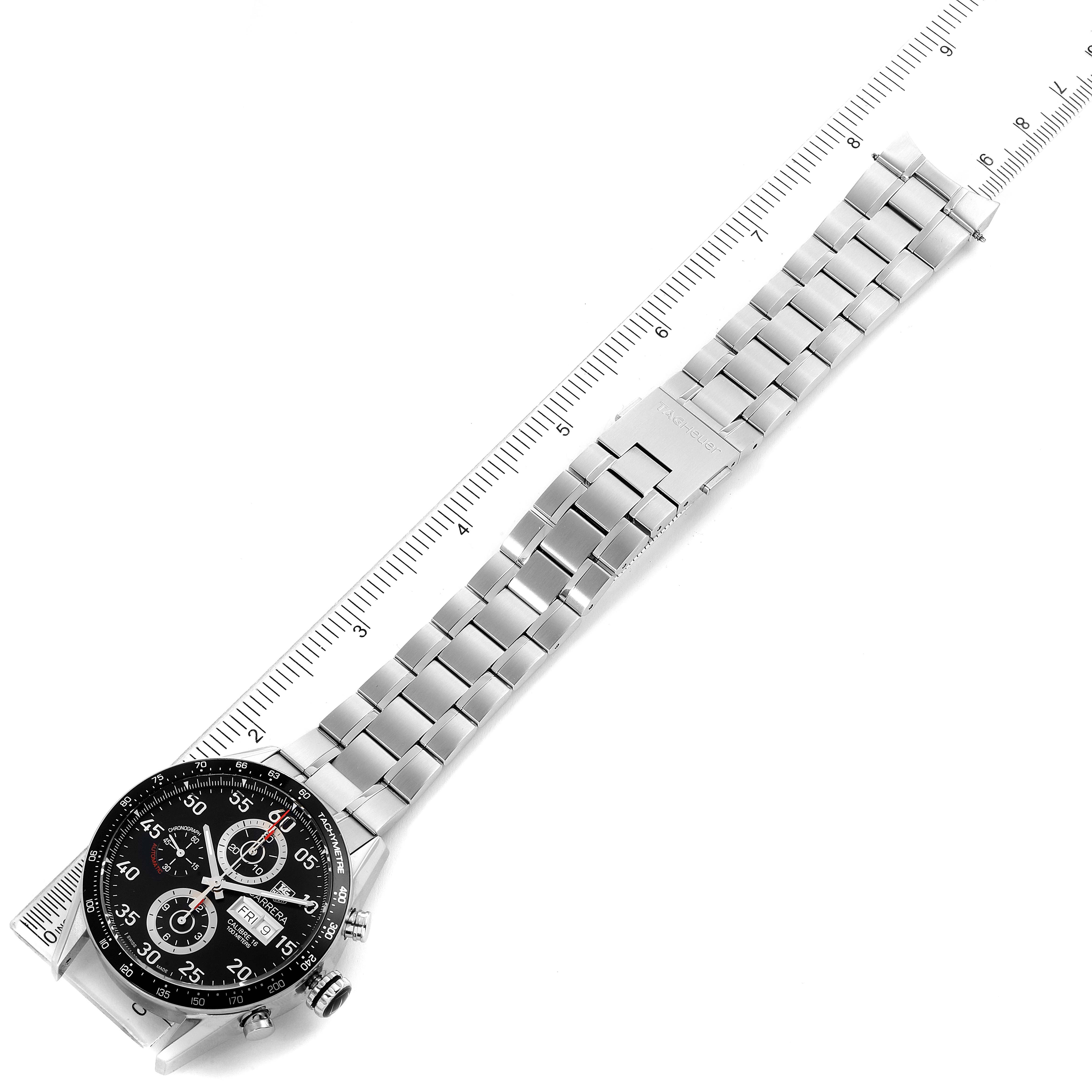 The image shows a top view of a Tag Heuer Carrera CV2A10.BA0796 Men's Stainless Steel Black Dial CV2A10.BA0796 Men's Stainless Steel Black Dial watch, including its face and stainless steel bracelet, next to a ruler.