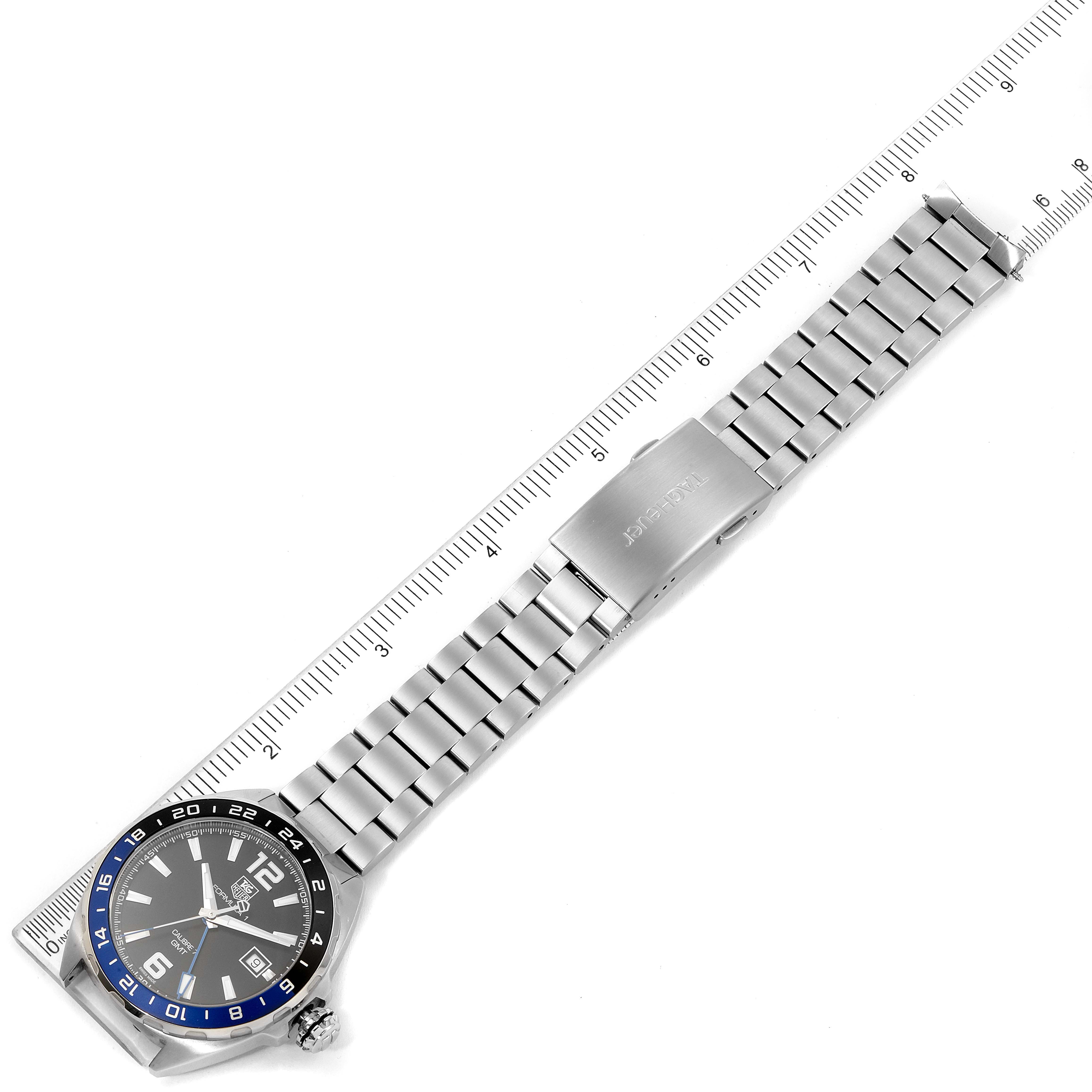 The image shows a top-down view of the Tag Heuer Formula 1 WAZ211A.BA0875 Men's Stainless Steel Black Dial WAZ211A.BA0875 Men's Stainless Steel Black Dial watch, highlighting its face, bezel, and metal band in alignment with a ruler.