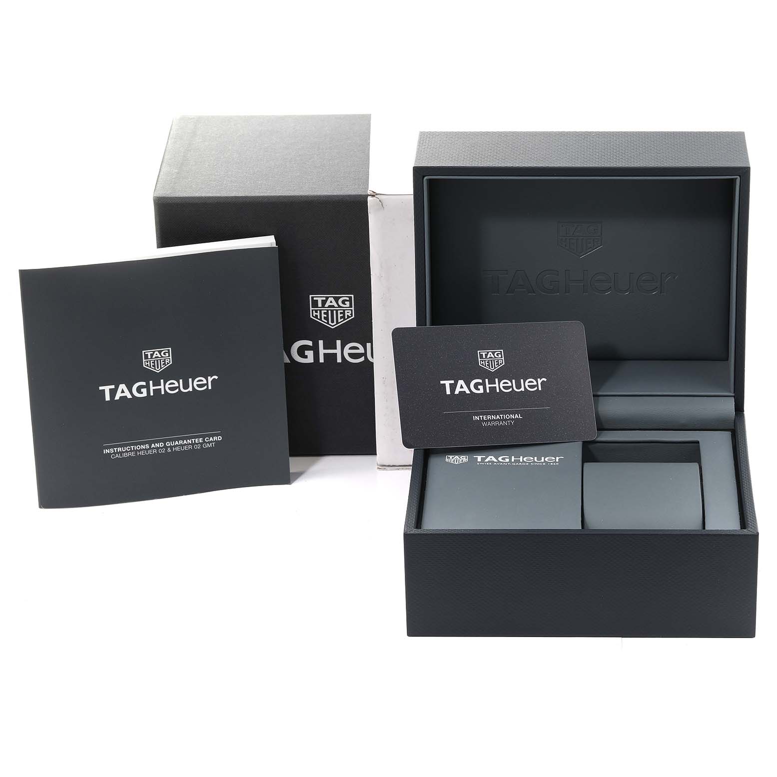 The image shows the packaging and accessories for the Tag Heuer Monaco CBL2113 Men
s Stainless Steel Black Dial CBL2113 Men
s Stainless Steel Black Dial watch, including the box, instruction booklet, and warranty card.