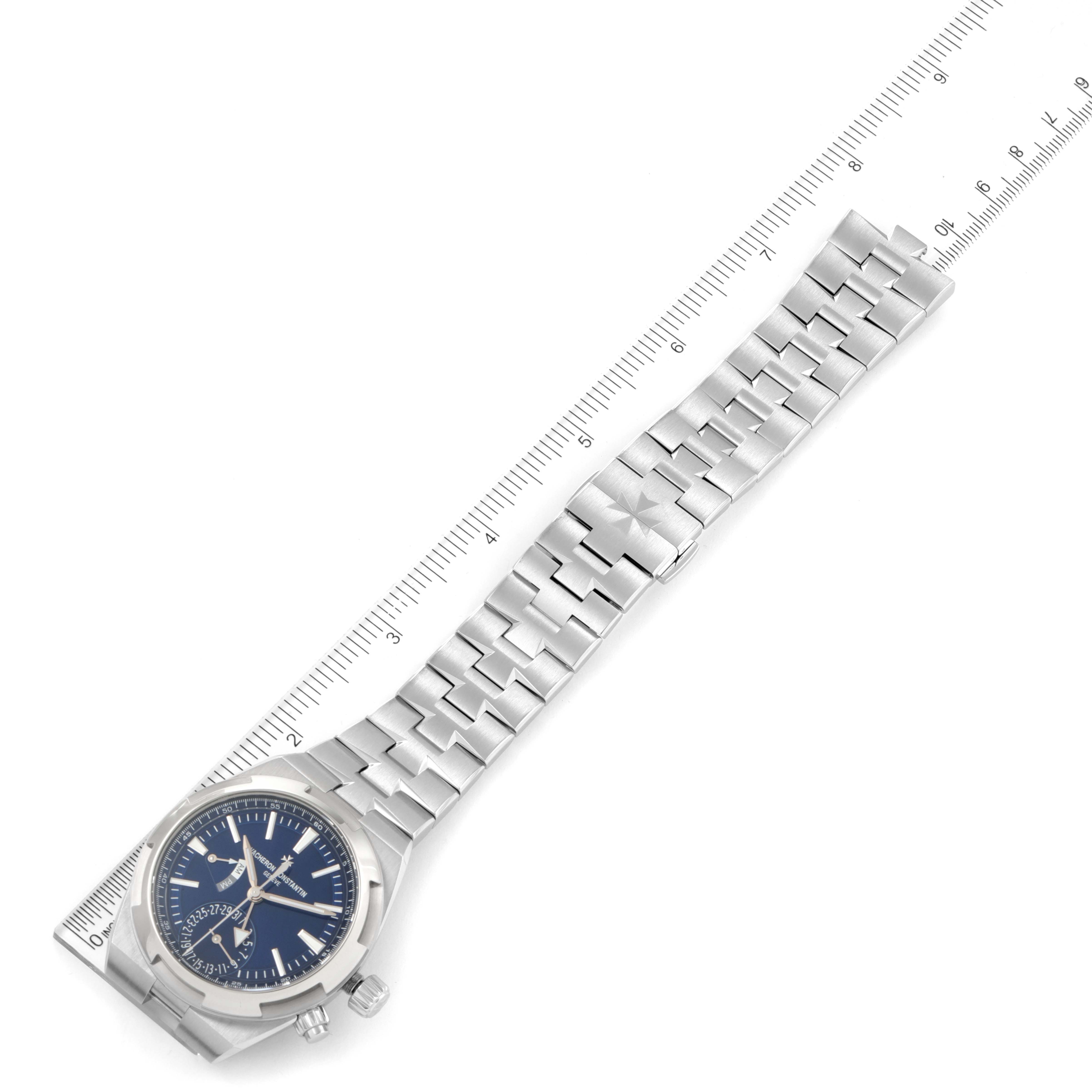 The image shows the face and bracelet of a Vacheron Constantin Overseas 7900V/110A-B334 Men's Stainless Steel Blue Dial 7900V/110A-B334 Men's Stainless Steel Blue Dial model watch, positioned alongside a ruler.