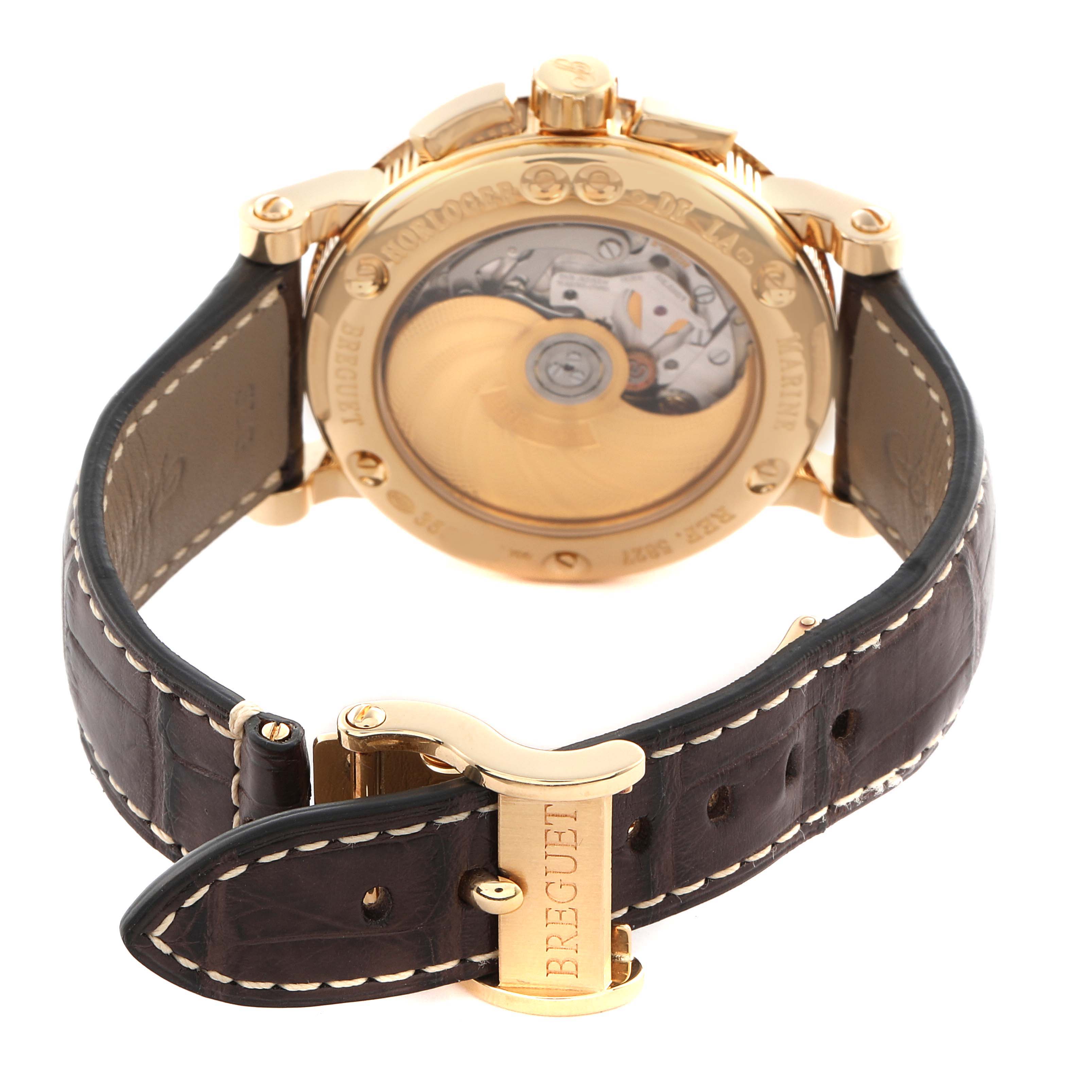 The Breguet Marine 5827BA/12/9Z8 Men's Yellow Gold Silver Dial 5827BA/12/9Z8 Men's Yellow Gold Silver Dial watch is shown from the back, displaying its open case back and leather strap with a clasp.